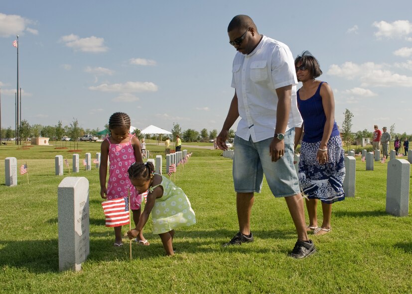 The Haynes family of Dyess Air Force Base places an American flag by a headstone for Memorial Day May 27, 2012, at the Texas State Veterans Cemetery in Abilene, Texas. Memorial Day is a day of remembering the men and women who died while serving in the United States Armed Forces. Formerly known as Decoration Day, it originated after the American Civil War to commemorate the Union soldiers who died in the Civil War. By the 20th century Memorial Day had been extended to honor all Americans who have died in all wars. (U.S. Air Force photo by Airman 1st Class peter Thompson/ Released)