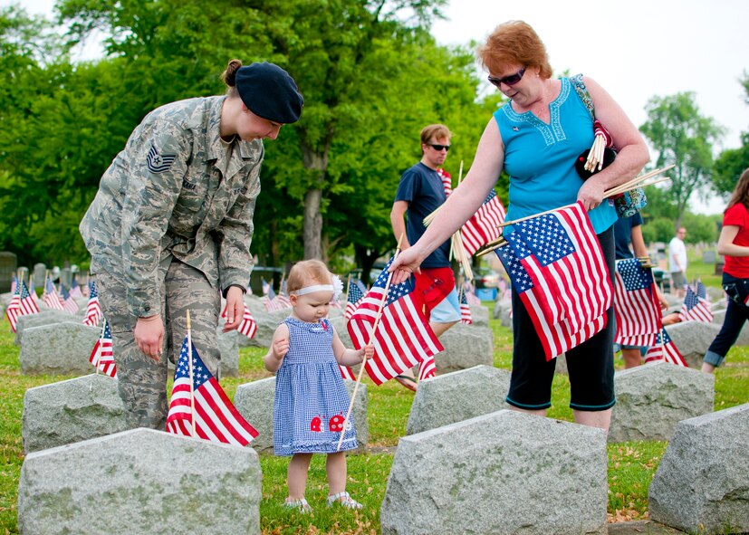 914th Security Forces Tech. Sgt. Cathleen Kania her daughter Kylie and mother Becky place American flags on veteran’s graves during a Memorial Day ceremony, May 28, 2012, Forest Lawn Cemetery Buffalo NY. During the morning thousands of flags where placed next to those men and woman who served in the United States military. (U.S. Air Force photo by Tech. Sgt. Joseph McKee)