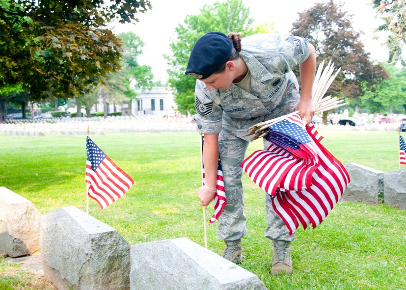 914th Security Forces Tech. Sgt. Lynn Magistrale places an American flag on a grave during a Memorial Day ceremony, May 28, 2012, Forest Lawn Cemetery Buffalo NY. During the morning thousands of flags where placed next to those men and woman who served in the United States military. (U.S. Air Force photo by Tech. Sgt. Joseph McKee)