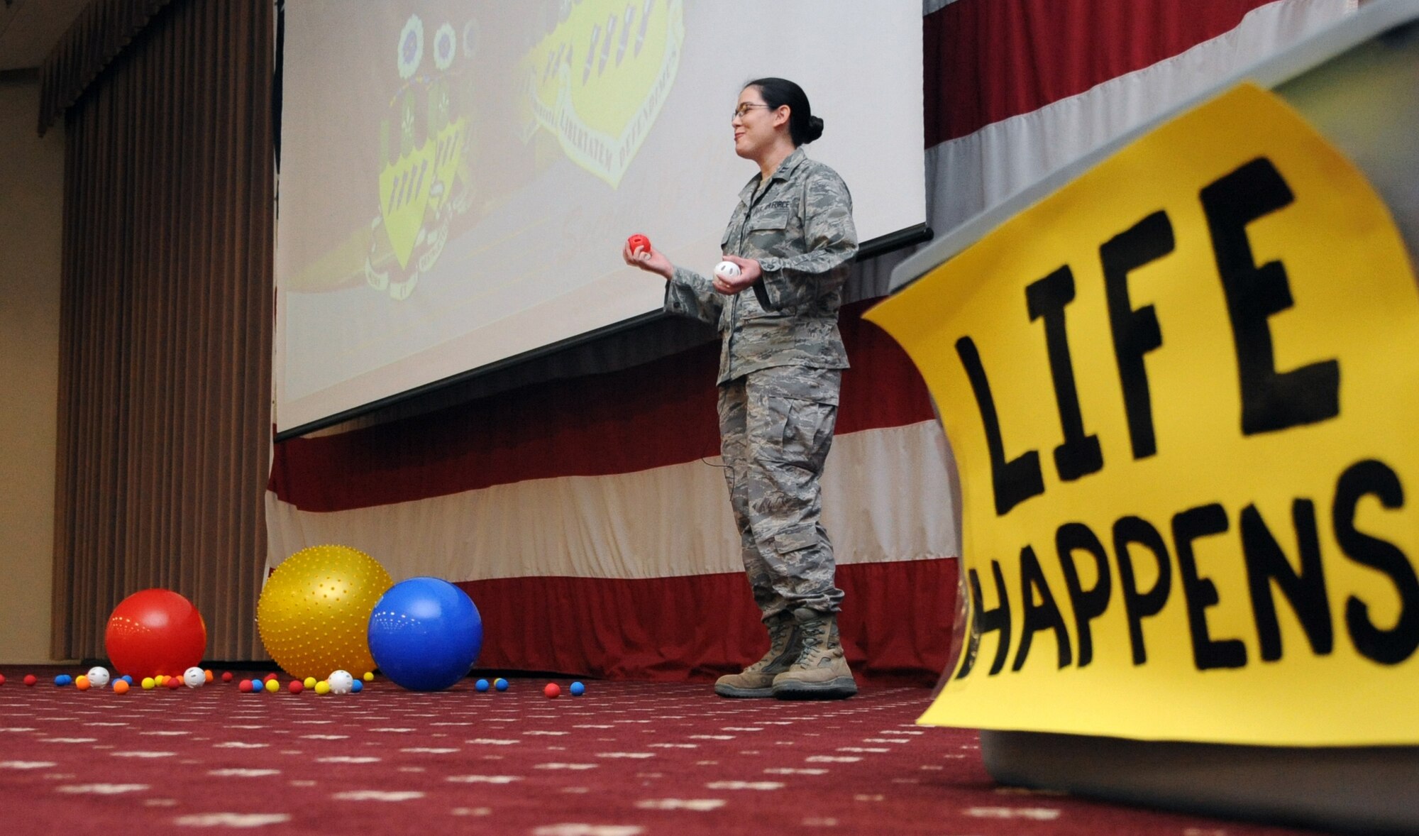 Chaplain (Capt.) Molly Lawlor, 2nd Bomb Wing, explains the effects stress can have on Airmen during a 2 BW All Call on Barksdale Air Force Base, La., May 24. She used multi-colored balls to demonstrate different stressors in a person's life. Lawlor, along with Airmen from the Mental Health Clinic, briefed Airmen on how to identify, resolve and help fellow Airmen deal with stress.(U.S. Air Force photo/Airman 1st Class Micaiah Anthony)(RELEASED)