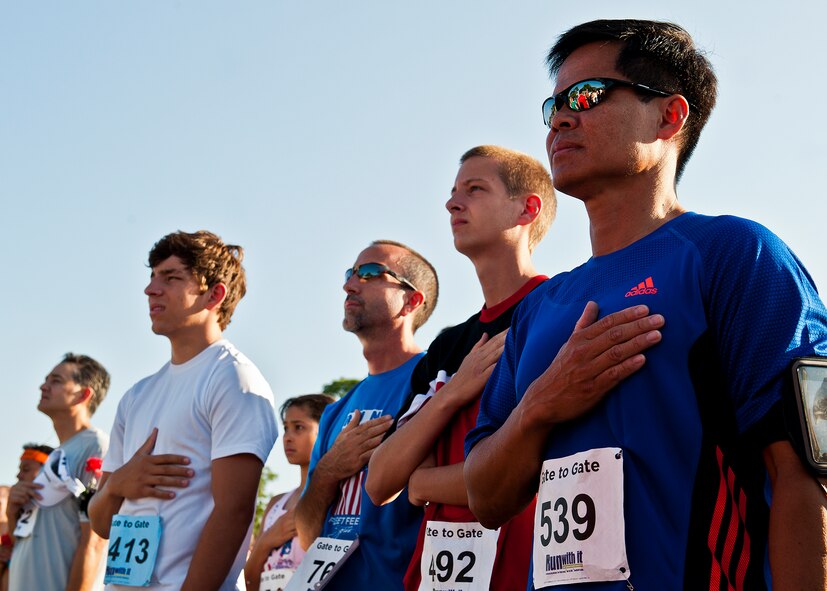 Ronald Morrell, of Air Force Operational Test and Evaluation Center Det. 2, and other runners listen to the national anthem prior to the Gate-to-Gate run May 28 at Eglin Air Force Base, Fla.  More than 1,600 people ran in the annual Memorial Day event.  (U.S. Air Force photo/Samuel King Jr.)