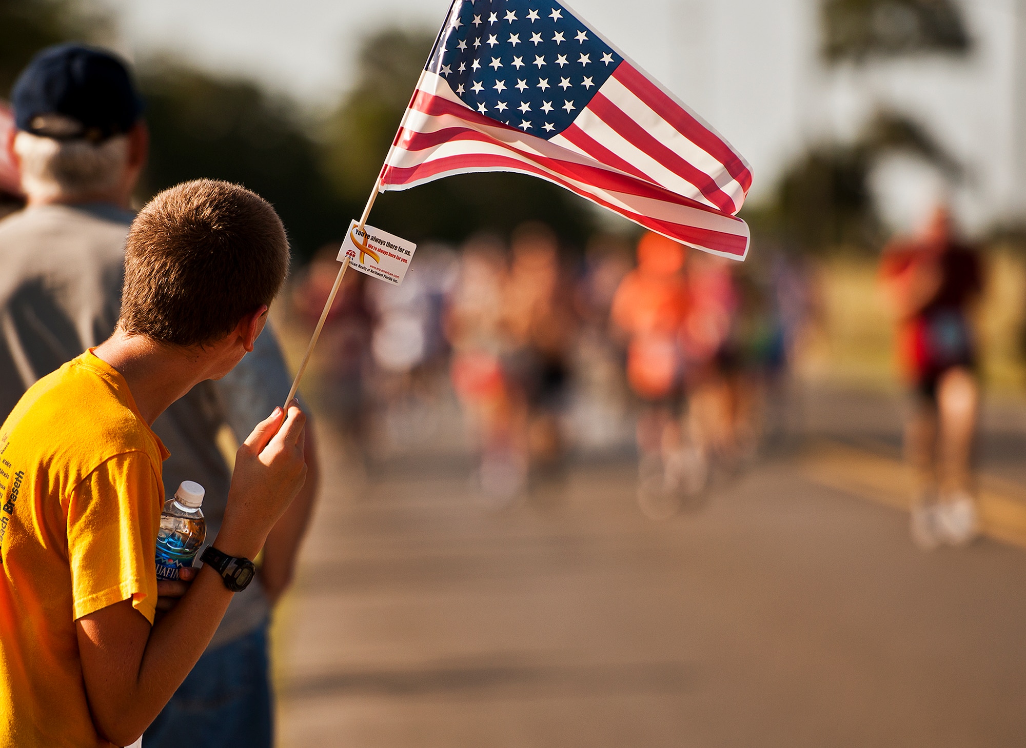 Jeremy Anderson watches as runners sprint for the finish line at the Gate-to-Gate run May 28 at Eglin Air Force Base, Fla.  More than 1,600 people ran in the annual Memorial Day event.  (U.S. Air Force photo/Samuel King Jr.)