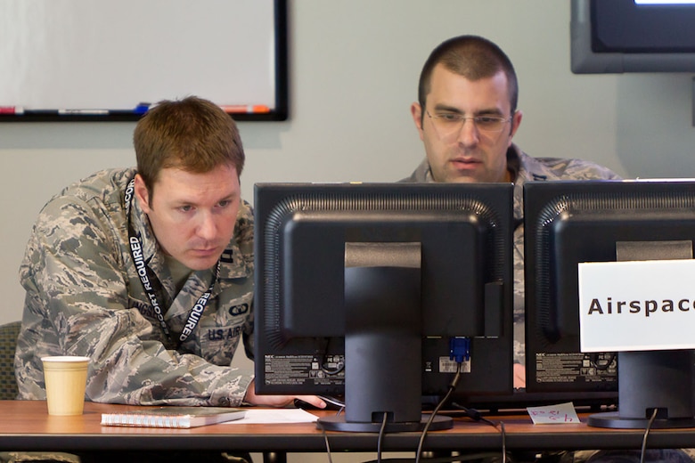 BEDFORD, Mass. - Capt. Tom Bilingsley (left) and Capt. Brendan Simison, operators from the 102nd Air Operations Group, Otis ANGB, Mass., evaluate a prototype initiative during a demonstration last month. During the demonstration, the Electronic System Center was assessing the capabilities of the Deliberate and Dynamic ISR Management, or D2ISRM, initiative to improve command and control of intelligence, surveillance and reconnaissance data. (Courtesy photo). 