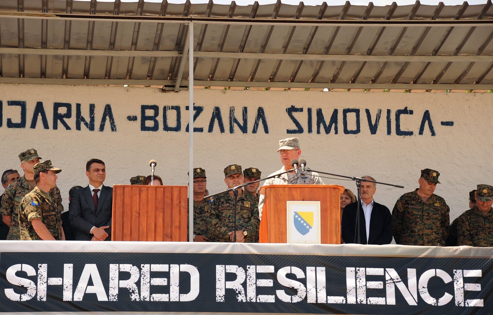 U.S. Air Force Col. Robert Marks, Shared Resilience 2012 co-director, addresses ceremony attendees during the SR12 opening ceremony here May 28, 2012. More than 500 military members from nine nations are participating in the annual U.S. Joint Chiefs of Staff sponsored exercise May 28 - June 8. The goals of the exercise are to strengthen interoperability, facilitate training in crisis response and disaster management, and validate the readiness of deployable military medical and humanitarian assistance teams. The exercise, in the spirit of partnership for peace, directly supports U.S. European Command's theater cooperation efforts and strategy for active security with European countries.