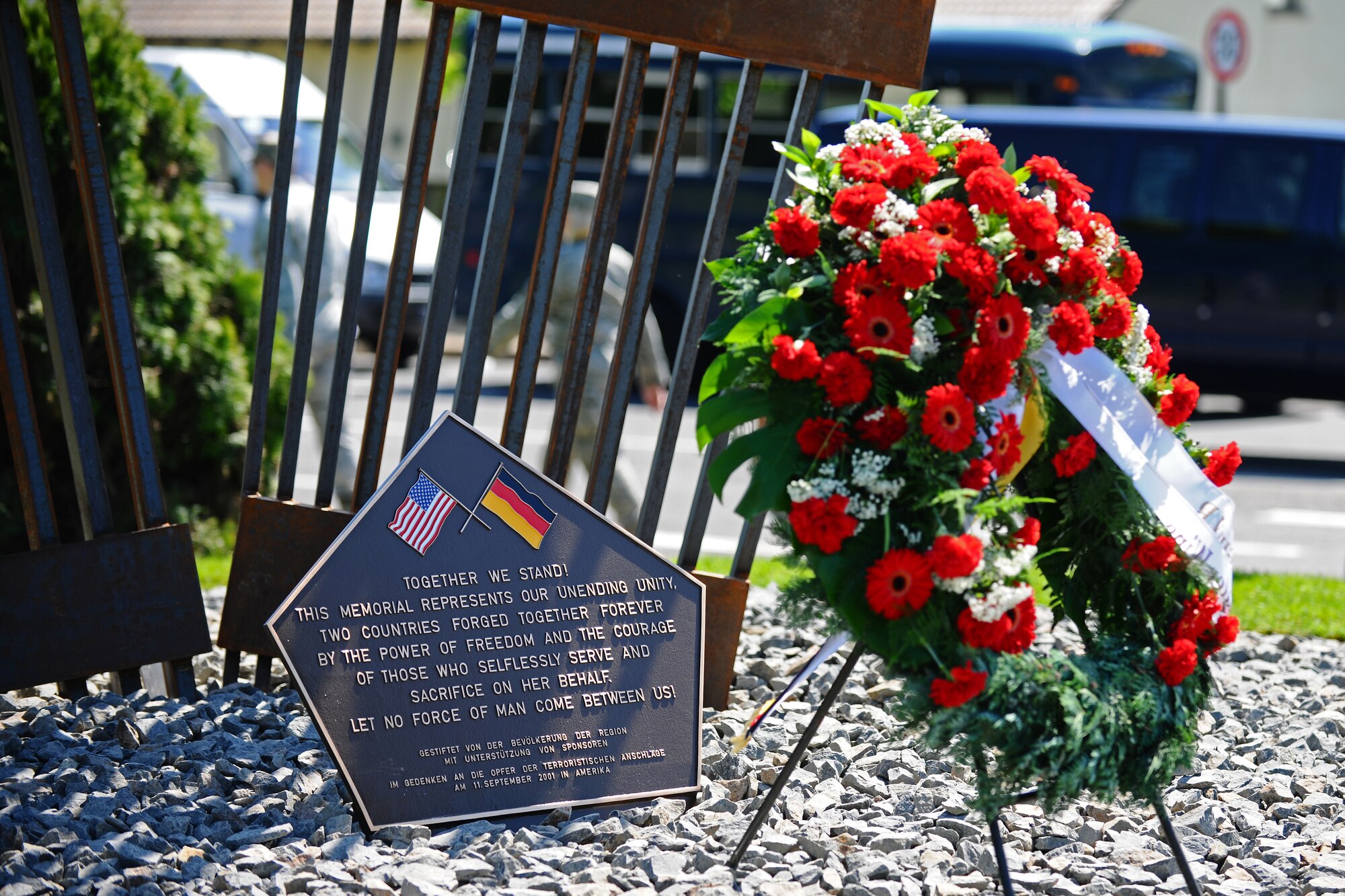 SPANGDAHLEM AIR BASE, Germany – A wreath sits on display next to a 9/11 memorial plaque after the 9/11 memorial dedication and wreath-laying ceremony here May 25. The 9/11 memorial was donated to the 52nd Fighter Wing by the Host Nation Council Spangdahlem and local businesses.  The sculpture was designed by Hubert Kruft, artist, from Niederpruem. (U.S. Air Force photo by Airman 1st Class Matthew B. Fredericks/Released)