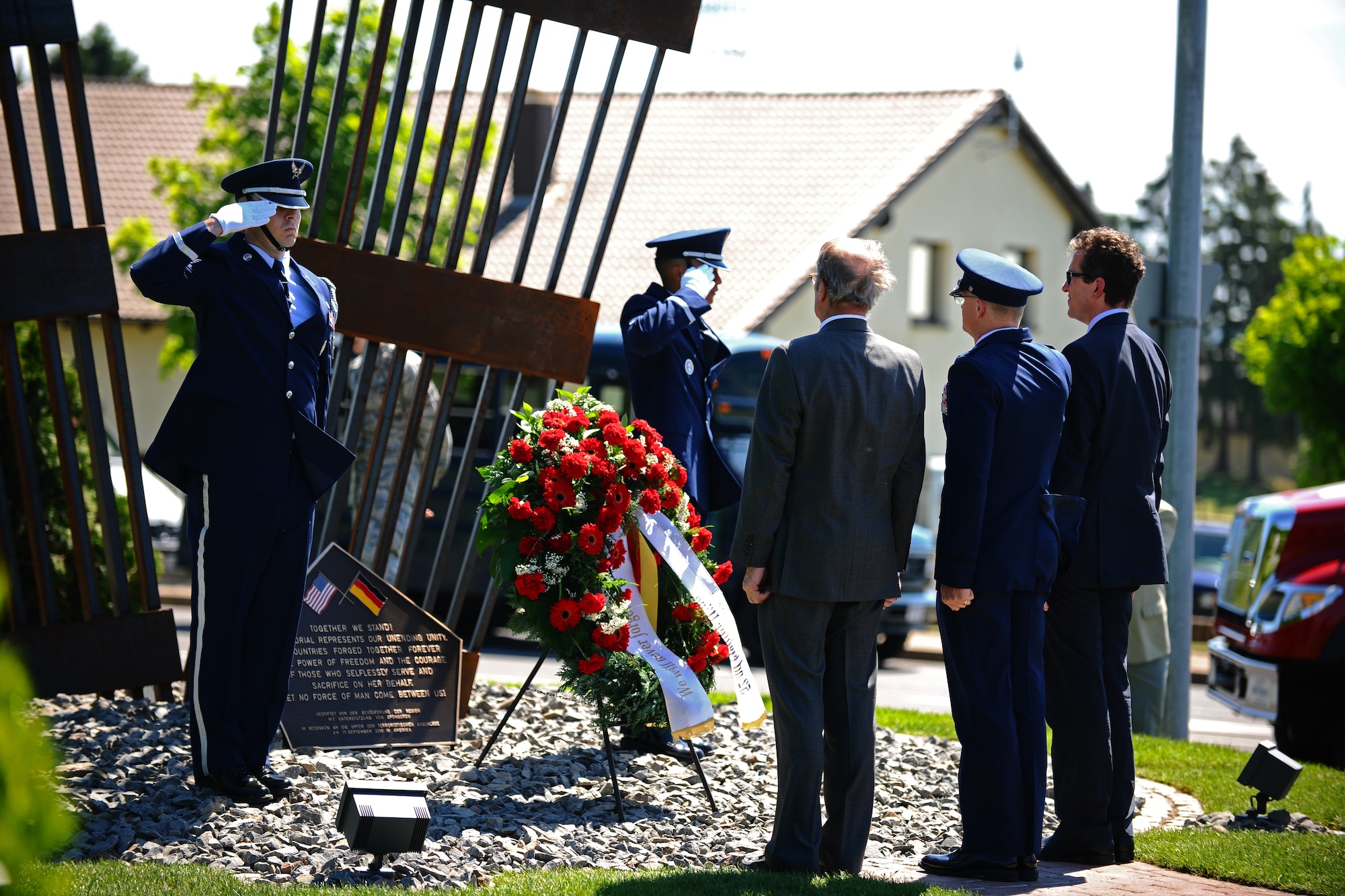 SPANGDAHLEM AIR BASE, Germany – Two 52nd Fighter Wing Honor Guard members and Col. Chris Weggeman, 52nd Fighter Wing commander, salute during the wreath-laying ceremony at the 9/11 memorial dedication while Michael Dietzsch, left, Host Nation Council Spangdahlem chairman, and Joachim Streit, Bitburg-Pruem Eifel County county commissioner, look on while “Taps” is played here May 25. The 9/11 memorial was donated to the 52nd FW by the Host Nation Council and local businesses.  The sculpture was designed by Hubert Kruft, artist, from Niederpruem. (U.S. Air Force photo by Airman 1st Class Matthew B. Fredericks/Released)
