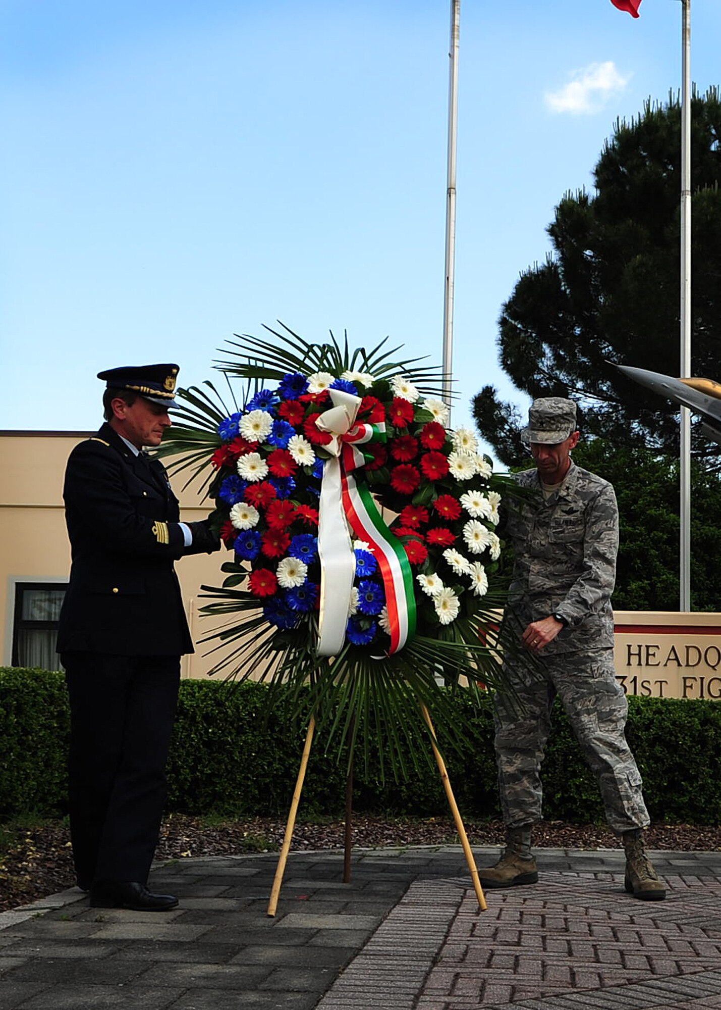 (From Left) Col. Luca Capelli, Pagliano e Gori Airport commander, and Brig. Gen. Scott Zobrist, 31st Fighter Wing commander, display a Memorial Day wreath May 25 at Aviano Air Base, Italy.  Memorial Day was observed annually on the last Monday of May to commemorate the men and women who died while serving in the U.S. Armed Forces. (U.S. Air Force photo by Staff Sgt. Evelyn Chavez)