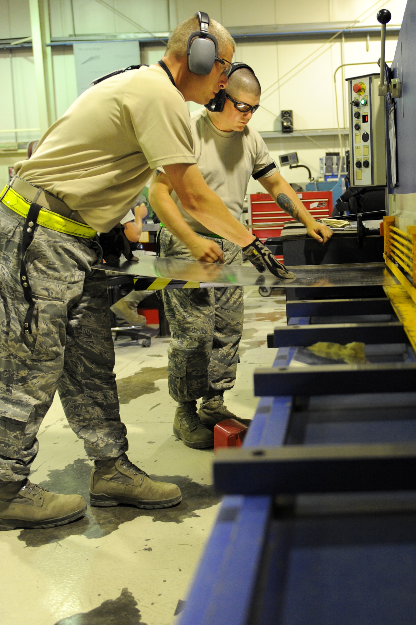 SOUTHWEST ASIA -- Tech. Sgt. Chris Feldhaus, front, and Airman 1st Class Rick Huard cut sheet metal May 28, 2012. They are both deployed to the 380th Expeditionary Maintenance Squadron. Feldhaus is from Beale, Air Force Base, Calif, and Huard is from Barnes Air National Guard Base, Mass. (U.S. Air Force photo/Master Sgt. Scott MacKay)