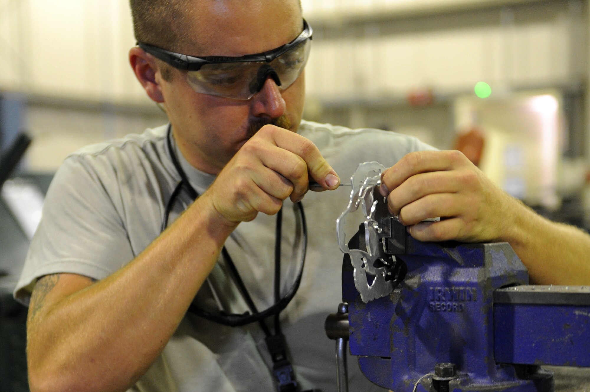 SOUTHWEST ASIA -- Staff Sgt. Beau Hensley shaves a metal part for a project May 28, 2012. Hensley is deployed to the 380th Expeditionary Maintenance Squadron from Mountain Home Air Force Base, Idaho. (U.S. Air Force photo/Master Sgt. Scott MacKay)