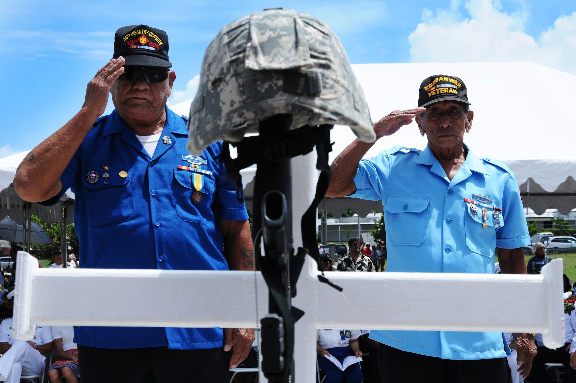 ANDERSEN AIR FORCE BASE, Guam- Tony Calvo and William Quenga of the Korean War Veterans Association present a salute to the cross honoring Korean War veterans during the Guam Veteran Cemetery Memorial May 28. The crosses honored seven wars of the American history ranging from World War I to the war in Iraq. (U.S. Air Force photo by Senior Airman Carlin Leslie/Released)