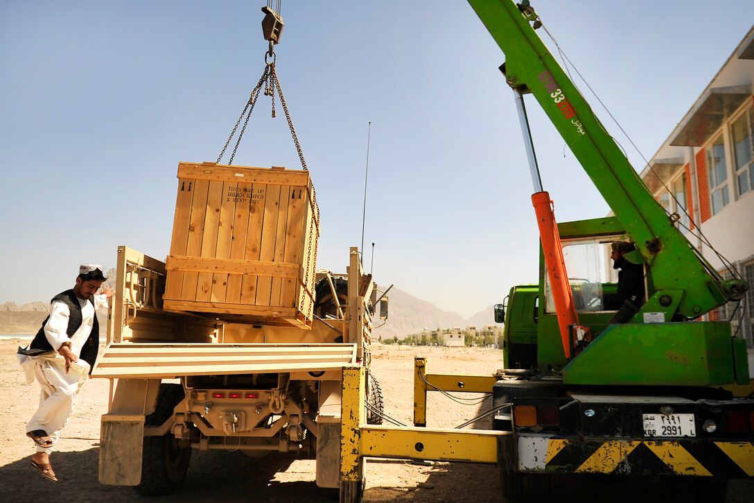 An Afghan contractor helps unload engineering equipment at Kandahar ...