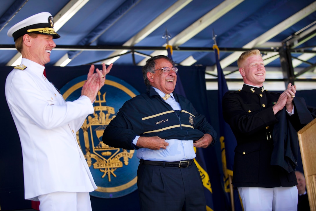 Defense Secretary Leon E. Panetta dons his Naval Academy warm-up suit as United States Naval Academy Superintendent Vice Adm. Michael H. Miller and U.S. Marine Corps 2nd Lt. Ian Cameron, 2012 class president, applaud during the United States Naval Academy 2012 Graduation and Commissioning ceremony in Annapolis, Md., May 29, 2012.