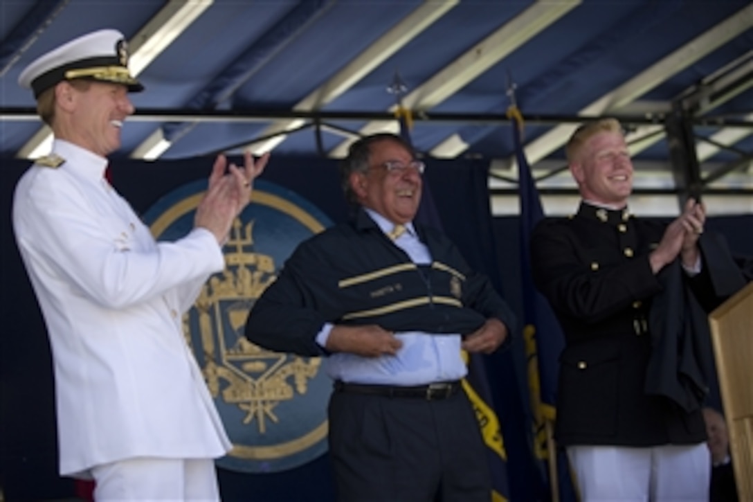 Secretary of Defense Leon E. Panetta dons his Naval Academy warm up suit as Naval Academy Superintendent Vice Adm. Michael H. Miller and U.S. Marine Corps 2nd Lt. Ian Cameron, the Class of 2012 president applaud at the United States Naval Academy 2012 Graduation and Commissioning ceremony in Annapolis, Md., on May 29, 2012.  