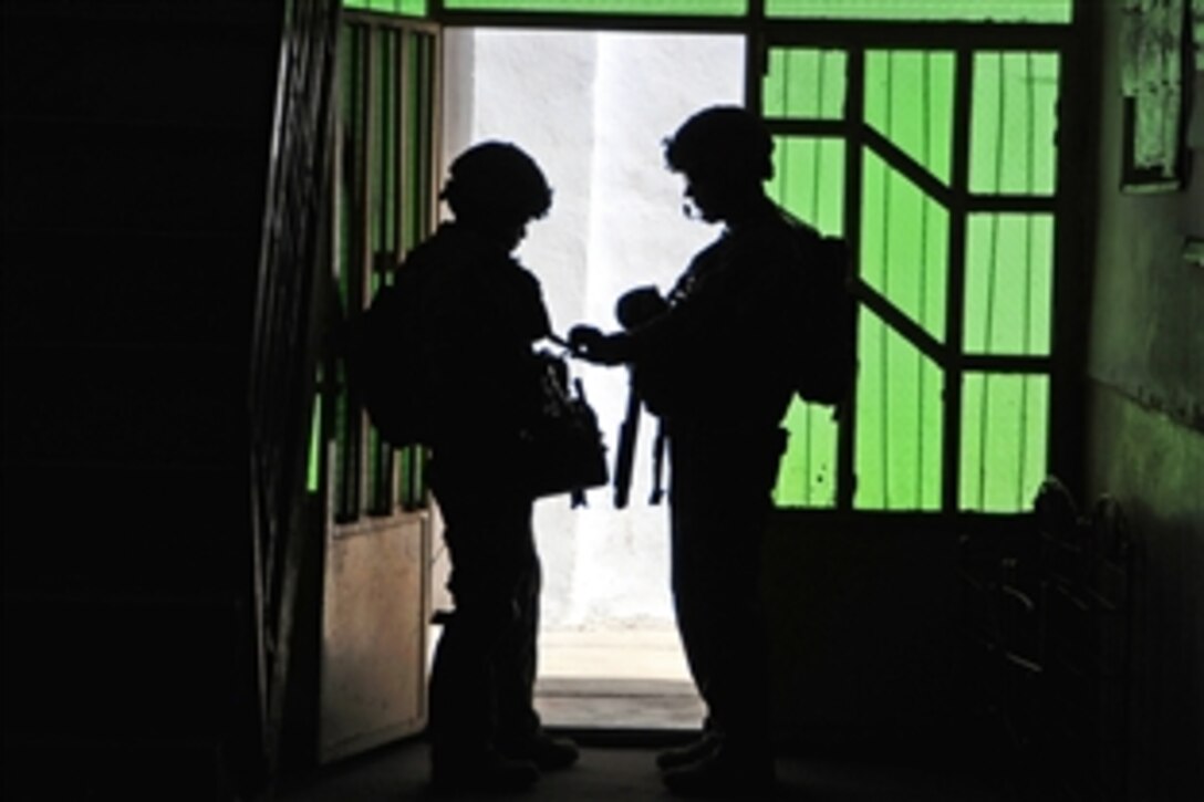 U.S. Army Sgt. 1st Class Michael Nelson, right, inspects a member of his team while providing security during a mission in Farah City, in Afghanistan's Farah province, May 26, 2012. Nelson is assigned to Provincial Reconstruction Team Farah, security force team, which is made up of National Guard infantrymen from Alaska.