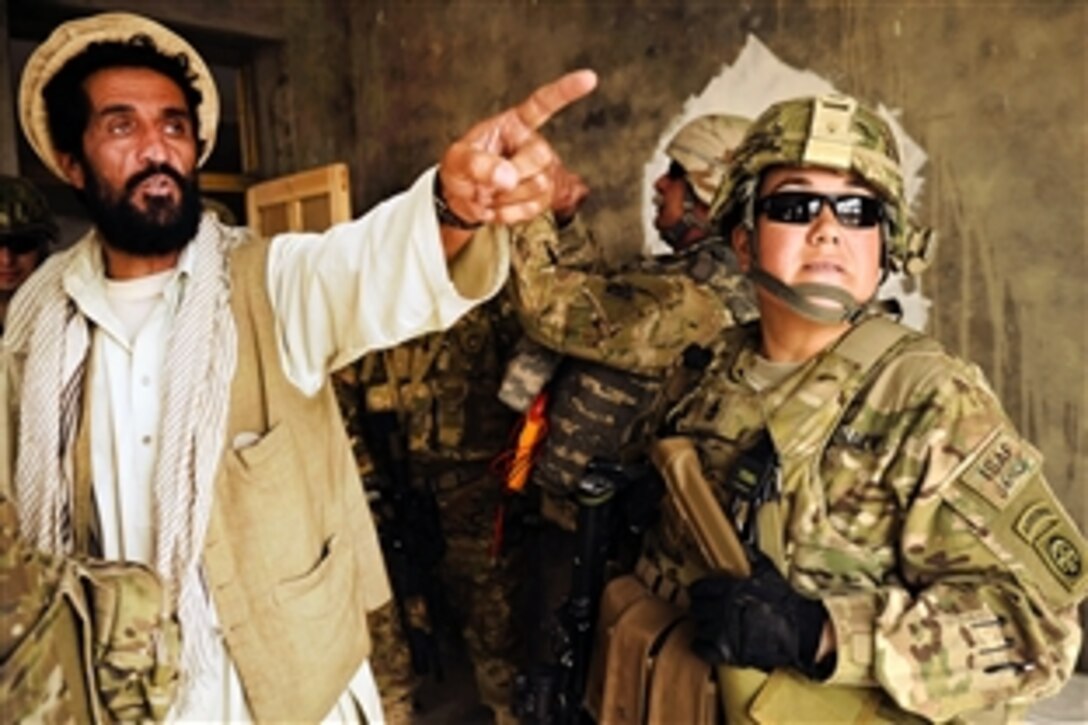 U.S. Navy Senior Chief Petty Officer Michelle Bernales talks with an Afghan contractor while conducting a site survey of the Sanjaray health clinic in Kandahar, Afghanistan, May 24, 2012. Bernales is assigned to the Kandahar Provincial Reconstruction Team.