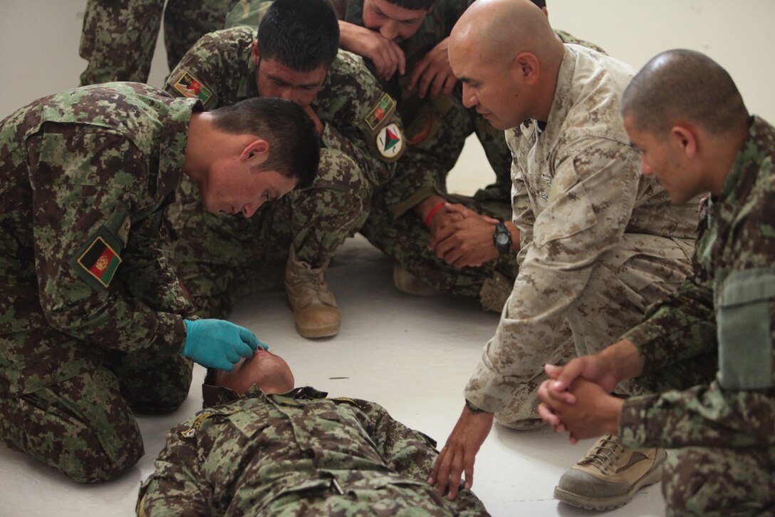 Petty Officer 1st Class Otto Giron, the medical advisor with the Combat Logistics Battalion 5 Embedded Partnering Team, observes a medical course with the 1st Brigade, Afghan National Army at Camp Garmser, Afghanistan, May 30. As part of the EPT, Giron provides guidance to the medical instructors throughout the 8-week long combat life saving course. The soldiers practiced inserting a nasal pharyngeal airway for practical application of the procedure.