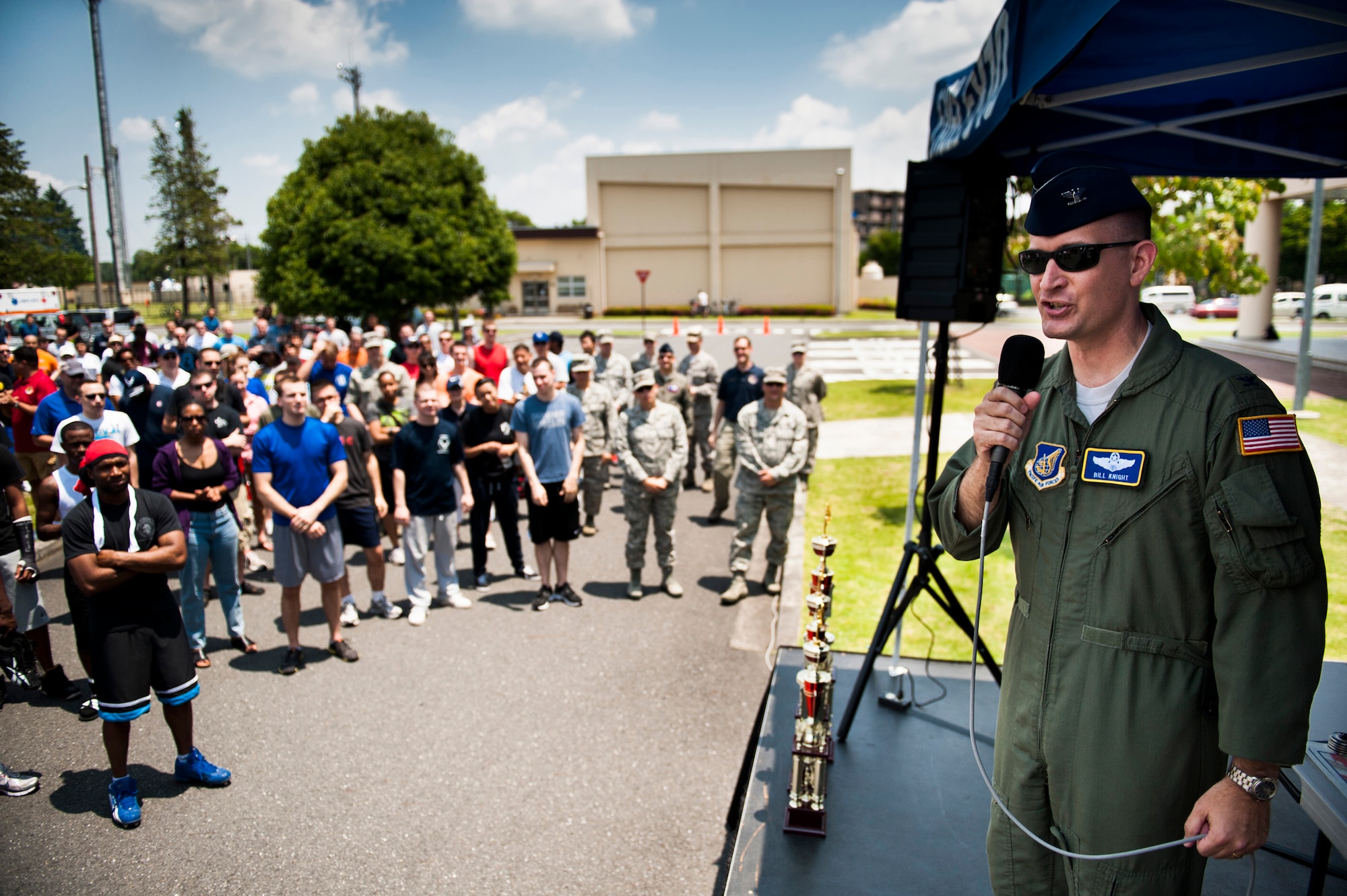 YOKOTA AIR BASE, Japan -- Col. Bill Knight, 374th Airlift Wing commander, addresses assembled Airmen and a live radio audience at the start of Airmen Appreciation Day at Yokota Air Base, Japan, May 29, 2012. Knight thanked everyone for their hard work during the consolidated unit inspection earlier that month and encouraged anyone still at work to come out and take part in the festivities. (U.S. Air Force photo by Staff Sgt. Samuel Morse)