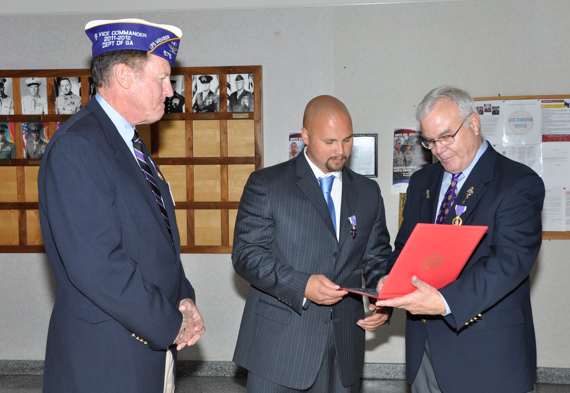 Marine Sgt. Monroe F. Seigle is congratulated by senior members of the Purple Heart Association following a ceremony on May 30 at the Navy Operations Support Center on Dobbins Air Reserve Base.  Seigle, 32, currently a senior at Kennesaw State University, was injured when his vehicle was struck by an improvised explosive device near Haditha, Iraq. (U.S. Air Force photo/Senior Airman Elizabeth Gaston/Released)