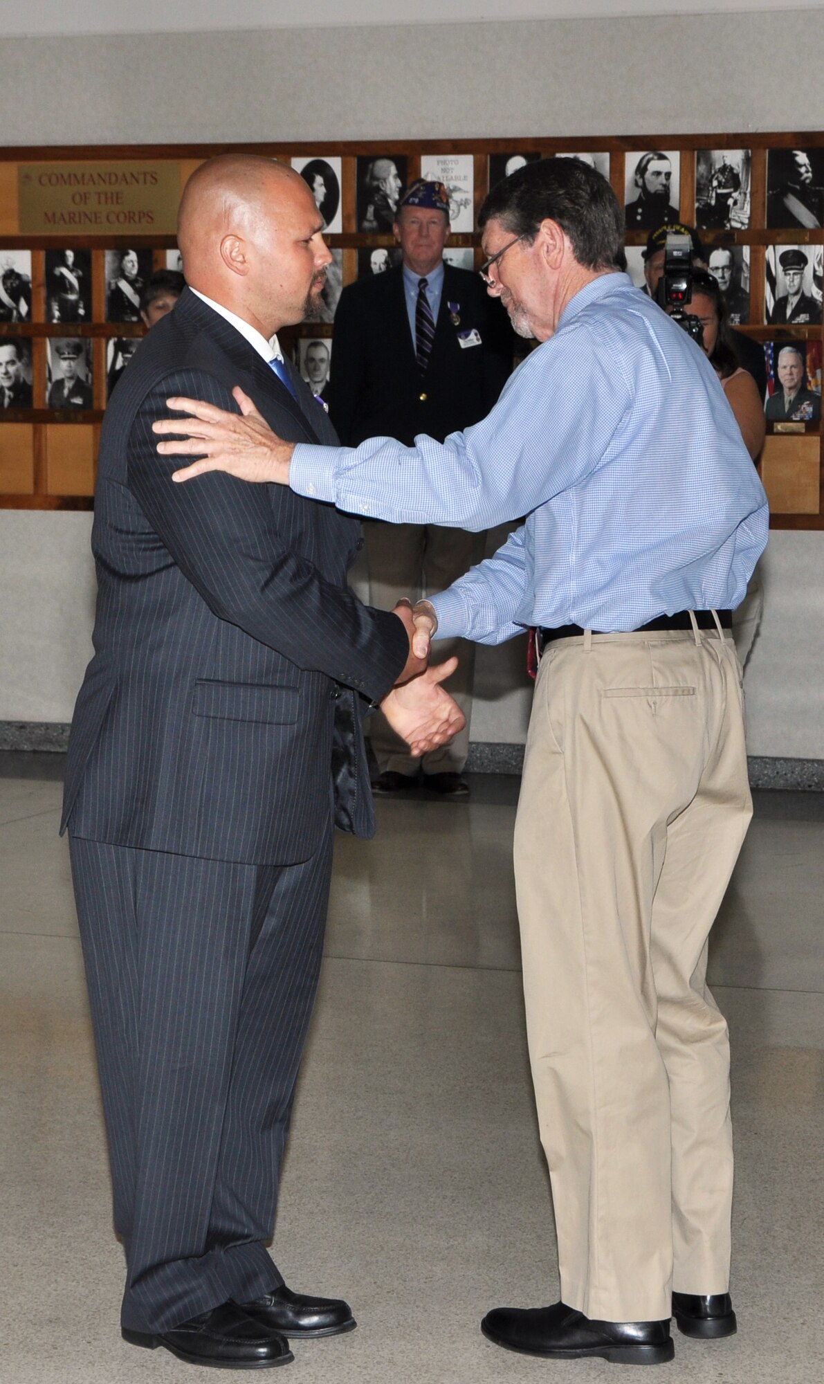 Marine Sgt. Monroe F. Seigle was presented the Purple Heart by his uncle, retired Army Sgt. Jerry Ritchie, combat veteran assigned to the 1st Cavalry Division during the Vietnam conflict, at a ceremony on May 30 at the Navy Operations Support Center on Dobbins Air Reserve Base.  Seigle, 32, currently a senior at Kennesaw State University, was injured when his vehicle was struck by an improvised explosive device near Haditha, Iraq. (U.S. Air Force photo/Senior Airman Elizabeth Gaston/Released)
