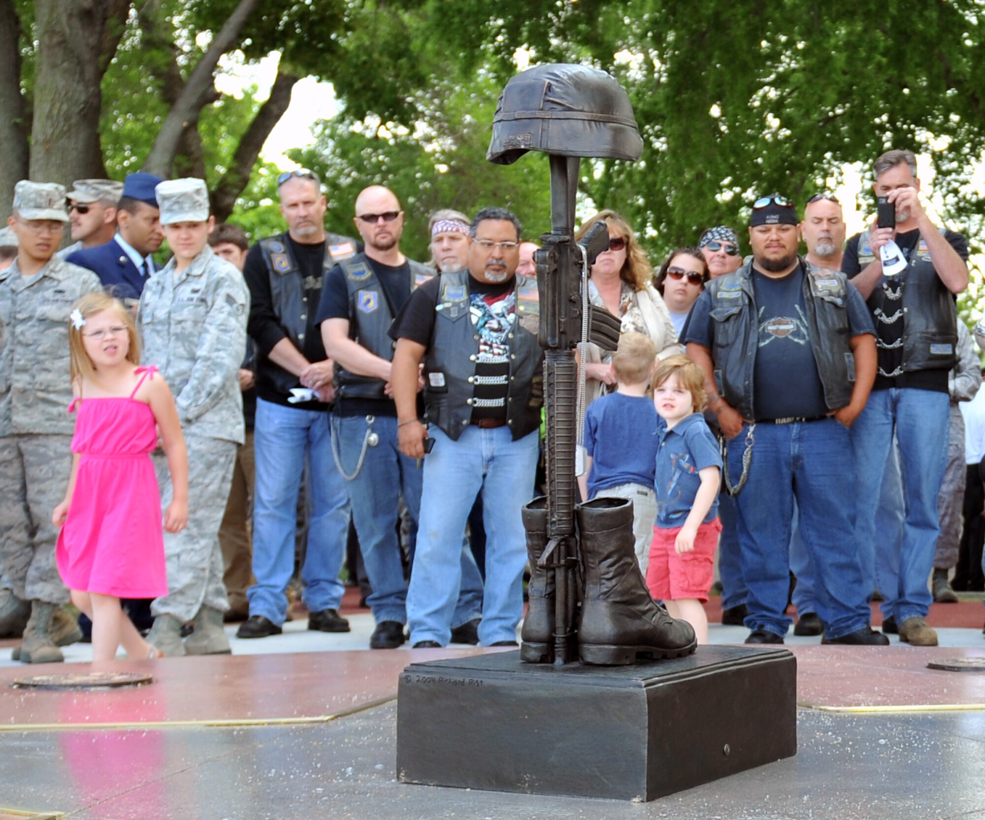 Crowds gather to get a closer look at the Fallen Warrior Memorial May 24 at Offutt AFB, Neb. The memorial features a polished black star with the seals of each service represented in bronzet. In the center of the star is the customary boots, rifle and helmet, constantly lit. (U.S. Air Force photo by Jeff W. Gates/Released)