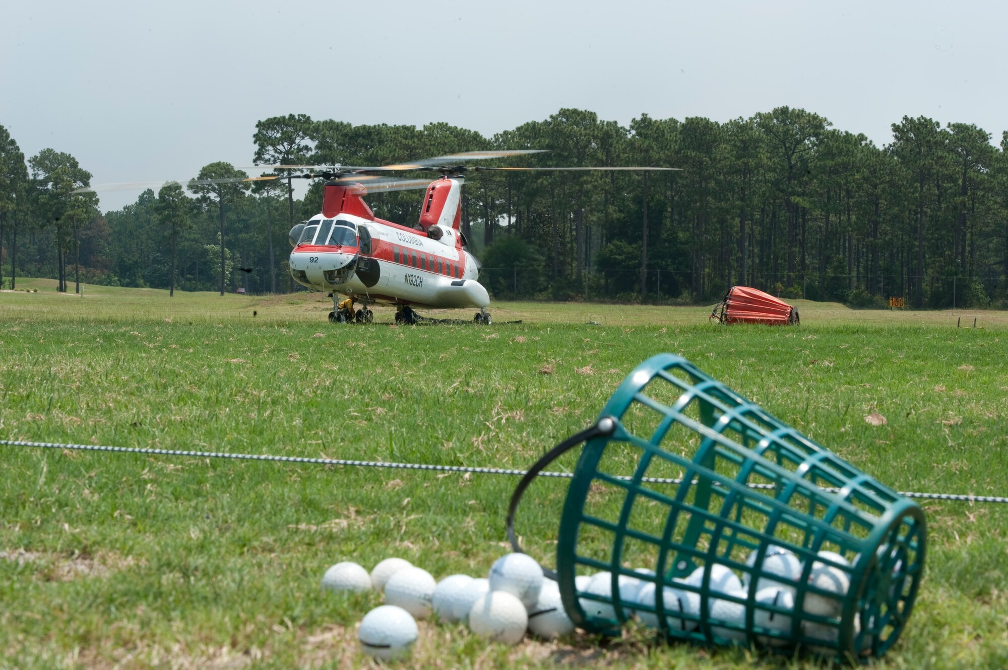 A contract helicopter attached to Jackson Guard prepares to take off from Gator Lakes golf course, Hurlburt Field, Fla., May 30, 2012.  The helicopter used a basket device haul water to aerially extinguish the fires. This fire asset is working in conjunction with a dozen other local agencies to isolate and extinguish the fires. (U.S. Air Force photo/Airman 1st Class Hayden K. Hyatt)
