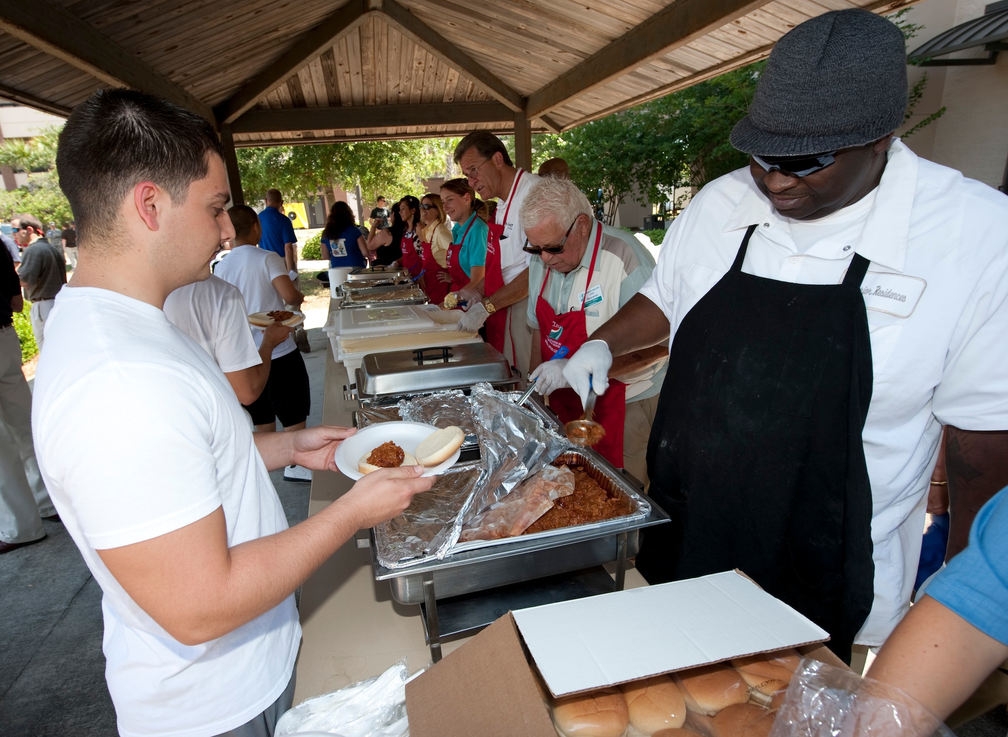 Airmen are served food by volunteers at the Third Annual Dorm Residents Appreciation Picnic held outside the Riptide Dining Facility at Hurlburt Field, Fla., May 24, 2012.  The event offered barbecue, drinks and desserts for dorm residents. (U.S. Air Force photo by Airman 1st Class Benjamin D. Kim)(Released)