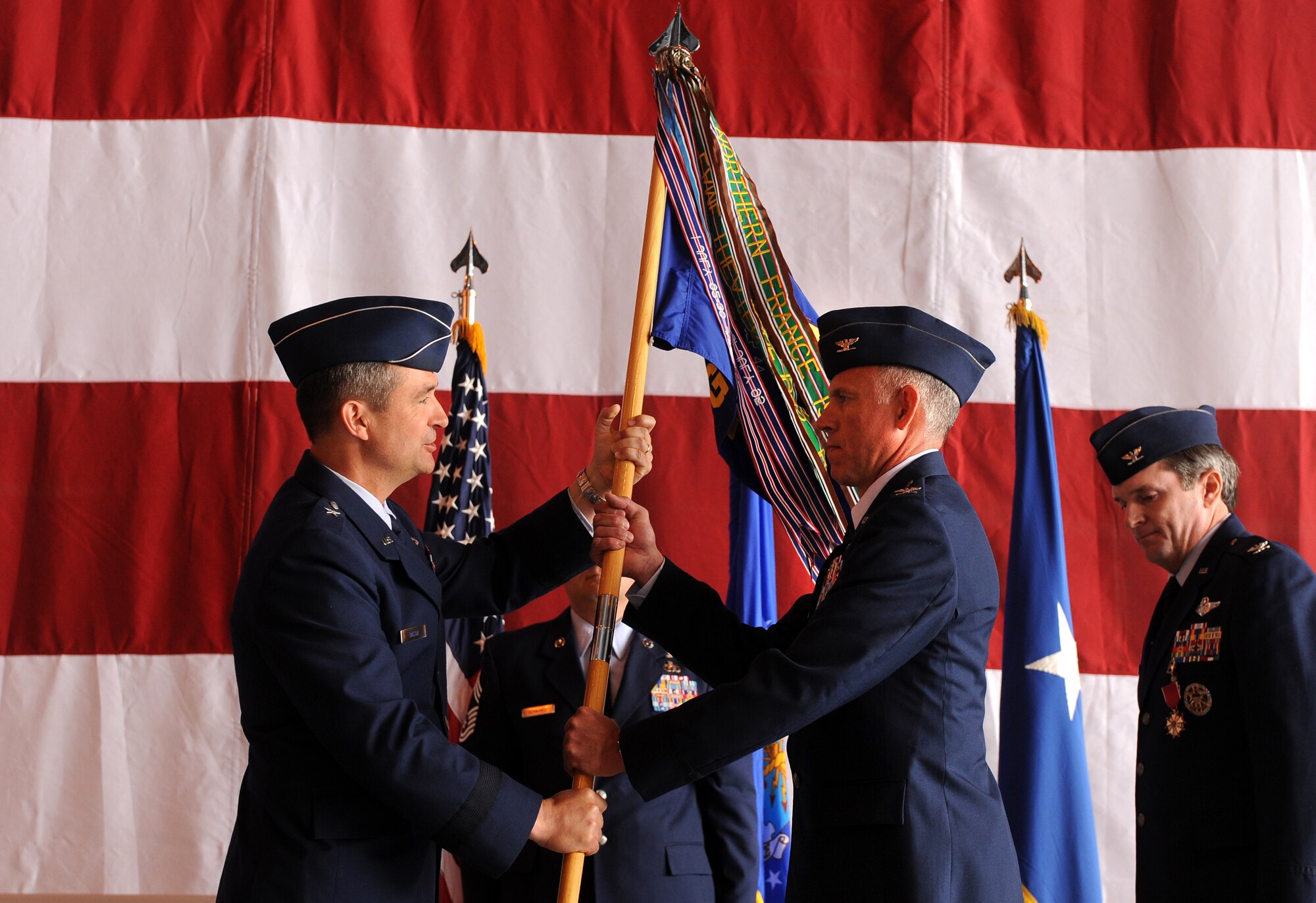U.S. Air Force Brig Gen. Donald Bacon, 55th Wing commander, gives the command guidon to Col. Russell Mammoser, incoming 55th Operations Group commander, during a formal change of command ceremony held May 24 in Dock 1 of the Bennie Davis Maintenance Facility at Offutt Air Force Base, Neb.  Hundreds of Airmen, family and distinguished visitors were in attendance for the change of command.  (U.S. Air Force photo by Josh Plueger)