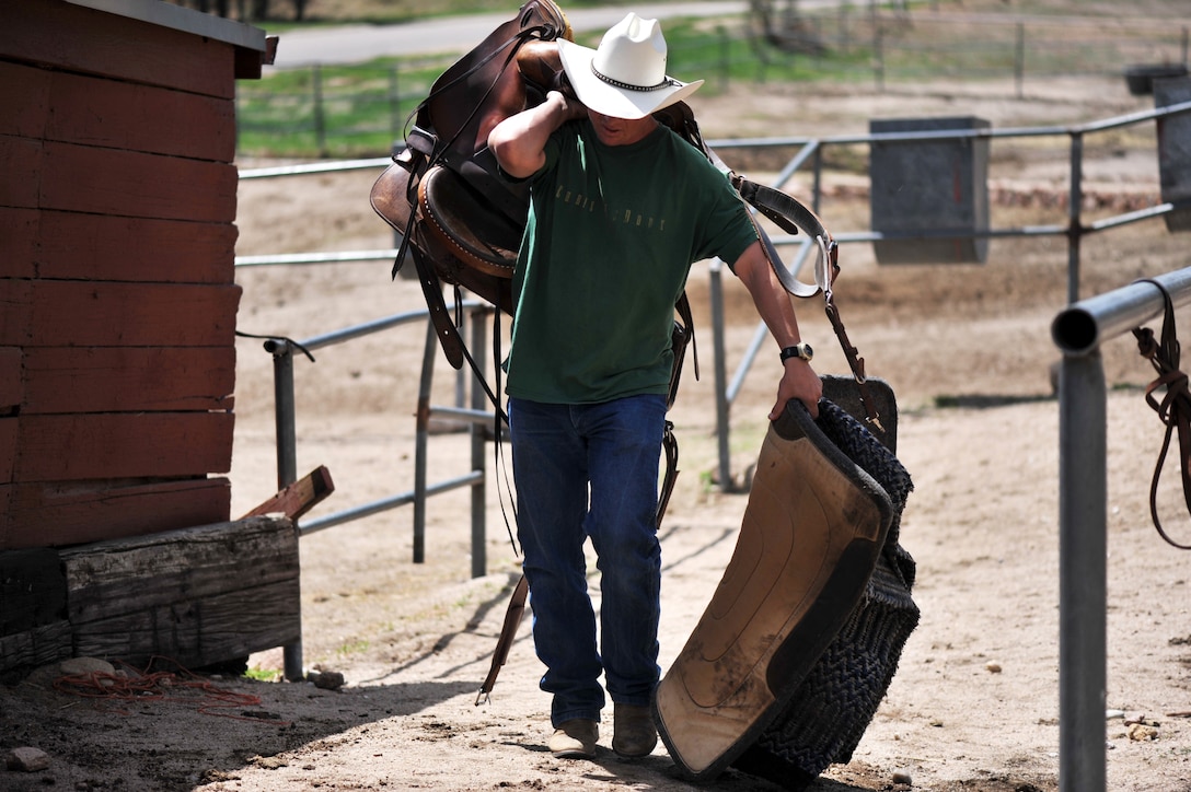 U.S. Army Sgt. Dale Chick returns a saddle to the stables after riding a horse at the equestrian center April 26, 2012, at the U.S. Air Force Academy in Colorado Springs, Colo. 
Chick said volunteering at the stables and working with horses helps him find inner peace and comfort after being deployed in Iraq and Afghanistan. (U.S. Air Force photo/Val Gempis)