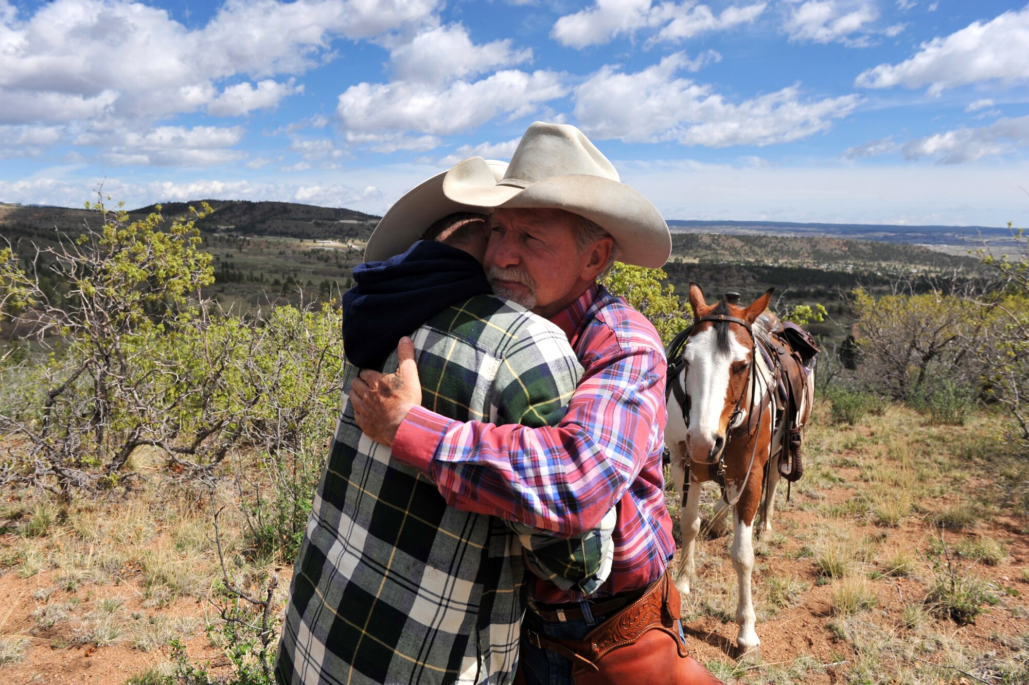 U.S. Army Sgt. Dale Chick (left) is hugged by Andy Popejoy after Chick talked about his experiences in Iraq at the equestrian center April 26, 2012, at the U.S. Air Force Academy in Colorado Springs, Colo. Chick said volunteering at the stables and working with horses helps him find inner peace and comfort after being deployed in Iraq and Afghanistan. Popejoy is an animal caretaker at the center. (U.S. Air Force photo/Val Gempis)