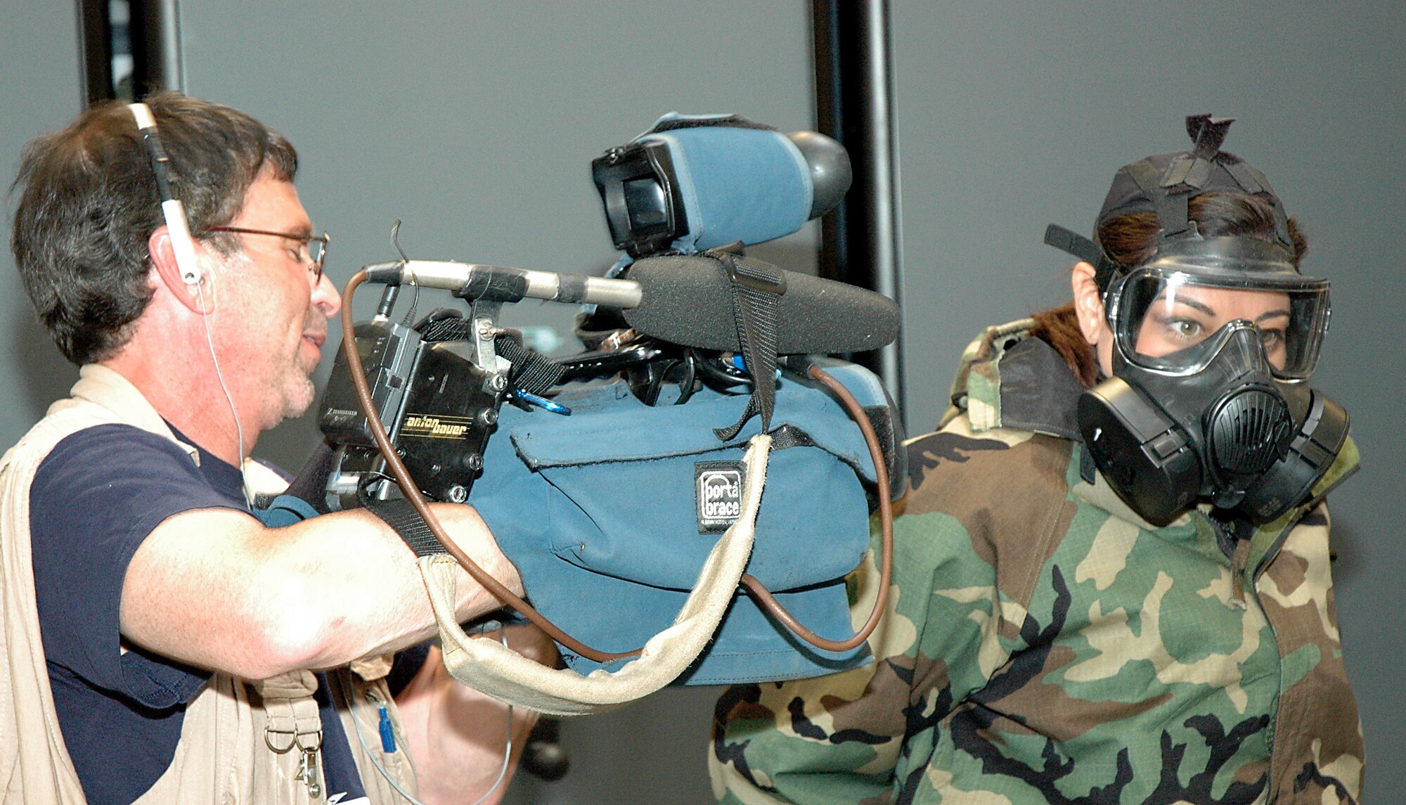 Wayne Pellenberg, a cameraman for WTKR News Channel 3 films reporter Bianca Martinez donning the Joint Service Lightweight Integrated Suit Technology (JSLIST) during the filming of a news segment called "Do My Military Job" at Joint Task Force Civil Support May 29, 2012.The news segment highlighted the Joint Service Lightweight Integrated Suit Technology, which provides protection against chemical, biological and radiological agents. JTF-CS anticipates, plans, and integrates USNORTHCOM chemical, biological, radiological and nuclear response operations. JTF-CS commands and controls designated Department of Defense forces to assist local, state, federal and tribal partners in saving lives, preventing further injury, and providing critical support to enable community recovery.(Official DOD photo by U.S. Air Force Tech. Sgt. Andrew Stephens)