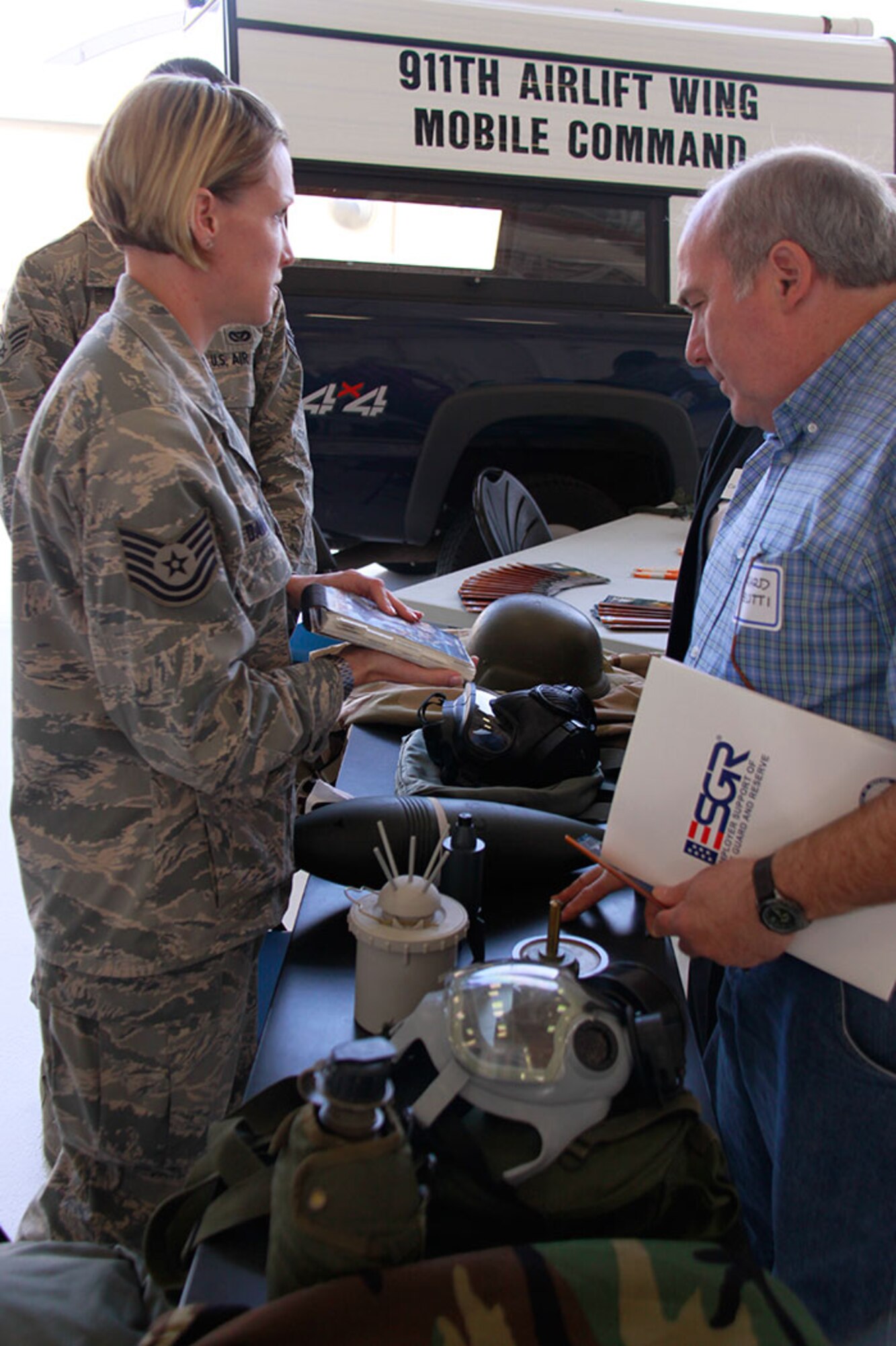 PITTSBURGH IAP ARS -- During the Honorary Commander’s Association event hosted by the 911th Airlift Wing, May 23, 2012, Tech. Sgt. Jessica Davis, emergency management specialist with the Civil Engineering Squadron, explains proper emergency management skills in the Airmen’s Manual to Richard Belotti, of the Allegheny County Airport Authority. The purpose of the Honorary Commander’s Association is to educate the local business community in the Army and Air Force Reserve’s role in the total force structure for national defense; to encourage employers to support employees who are members of the Reserve; and to foster a better understanding and community support of the local military units. The HCA event ended with an aerial drop performed by two C-130 H2’s at the drop zone in Burgettstown, Pa. (U.S. Air Force photo by Airman 1st Class Justyne Obeldobel/Released)
