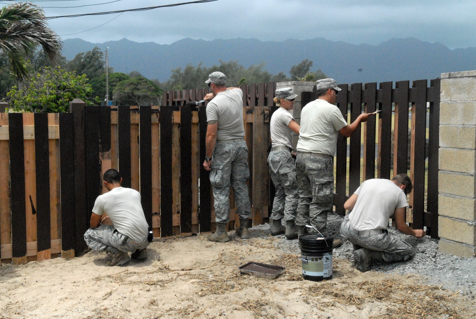 Airmen from the 647th Civil Engineer Squadron at Joint Base Pearl Harbor-Hickam, Hawaii, paint a fence at Bellows Air Force Station May 23 as part of the squadron's Prime BEEF exercise. Prime Base Engineer Emergency Force (BEEF) teams are rapidly deployable, specialized civil engineer units, that provide a full range of engineering support required to establish, operate, and maintain garrison and contingency airbases. (U.S. Air Force photo by 2nd Lt. Jessica Rowe)