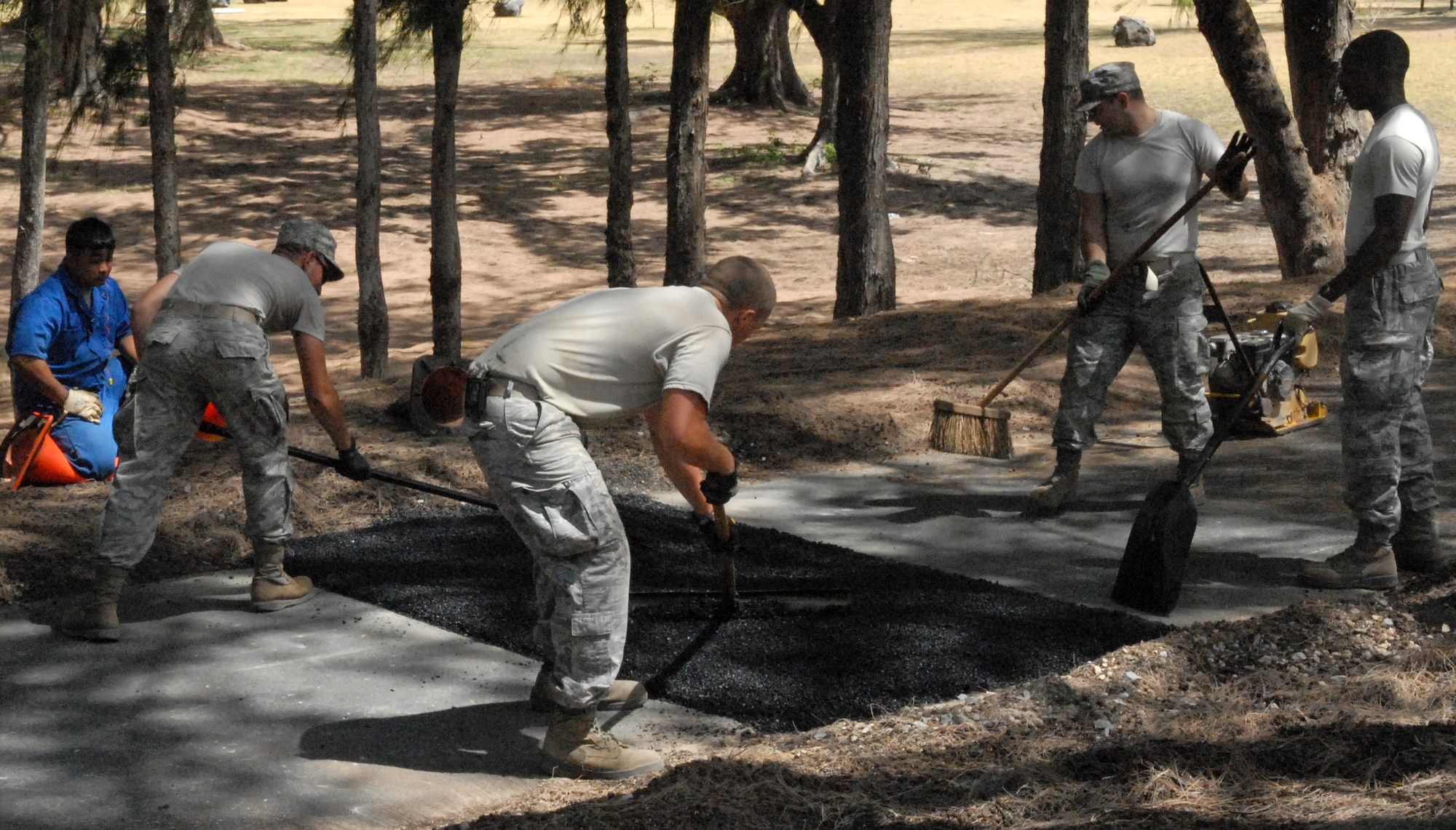 Airmen from the 647th Civil Engineer Squadron at Joint Base Pearl Harbor-Hickam, Hawaii, lay asphalt at Bellows Air Force Station May 23 as part of the squadron's Prime BEEF exercise. Prime Base Engineer Emergency Force (BEEF) teams are rapidly deployable, specialized civil engineer units, that provide a full range of engineering support required to establish, operate, and maintain garrison and contingency airbases. (U.S. Air Force photo by 2nd Lt. Jessica Rowe)