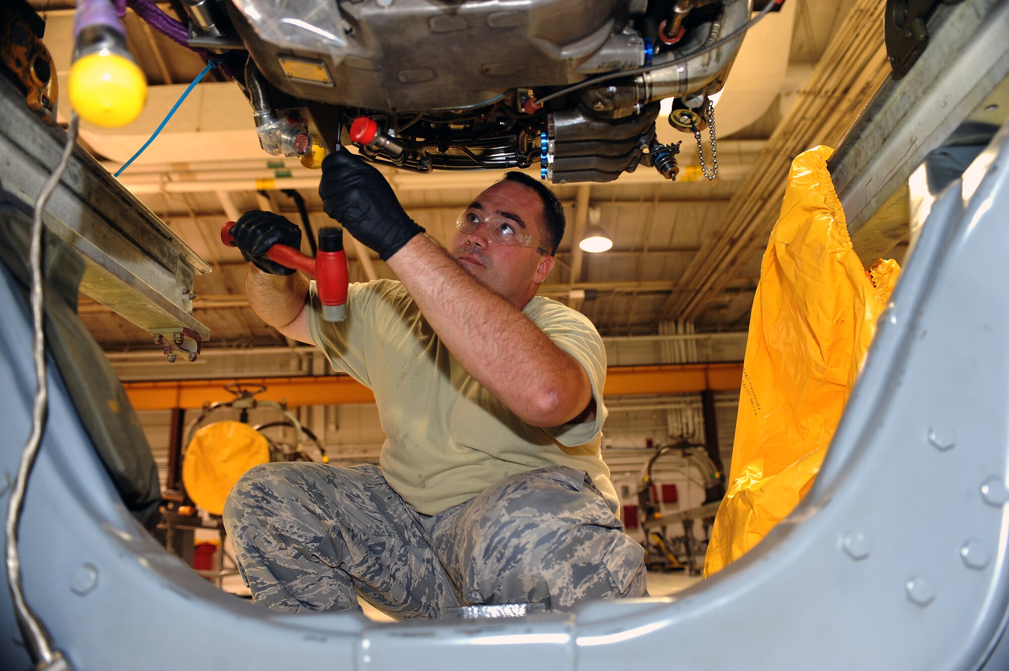 U.S. Air Force Staff Sgt. Douglas Melton hammers the sides of a washer on an alternating current rotor nut of an F-15E Strike Eagle on Seymour Johnson Air Force Base, N.C., May 29, 2012. The AC rotor generates electricity through currents to operate a Strike Eagle engine. Melton, 4th Component Maintenance Squadron propulsion mechanic, is from Altus, Okla. (U.S. Air Force photo/Airman 1st Class John Nieves Camacho/Released)
