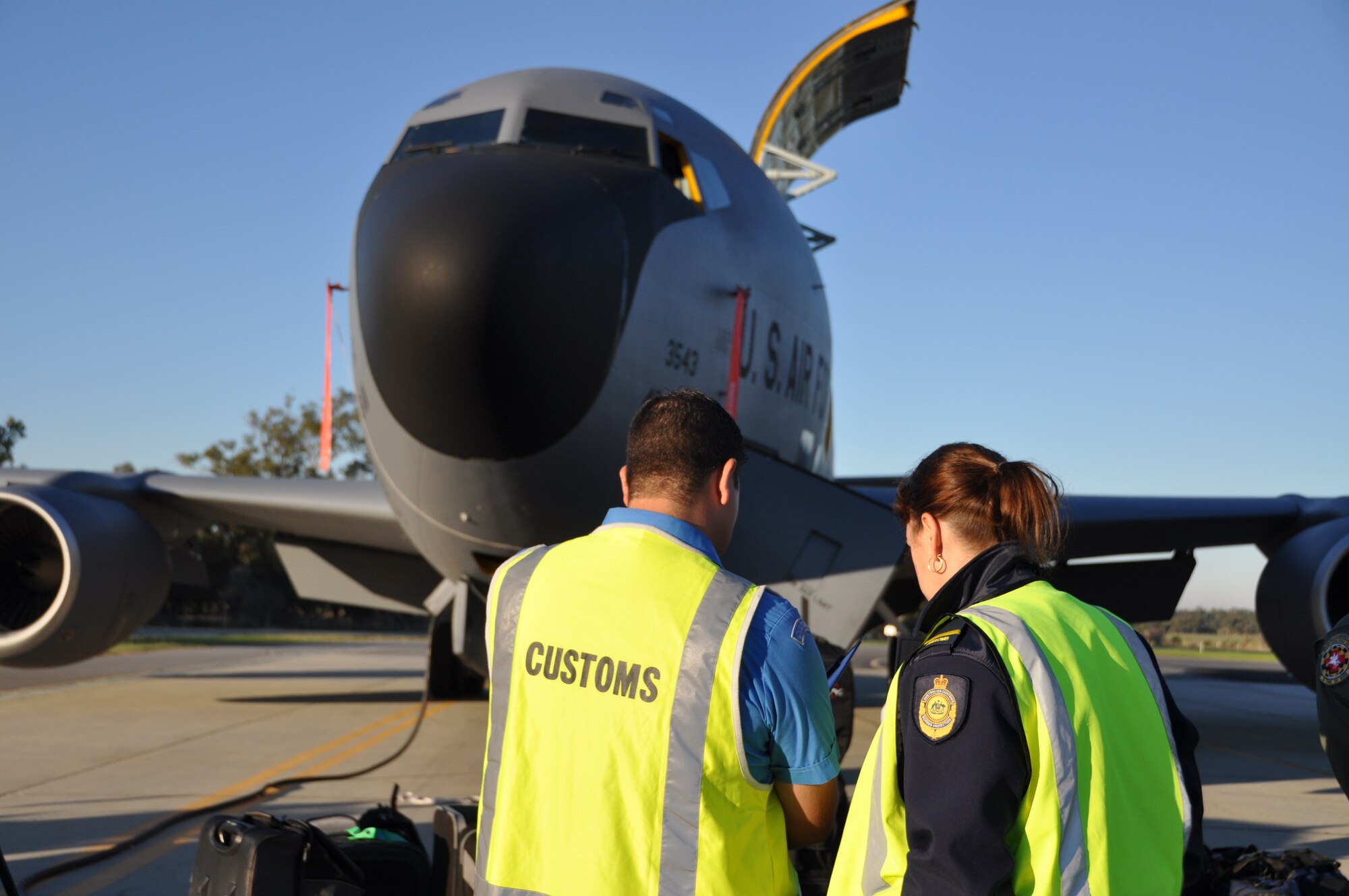 Australian Customs and Border Protection stand in front of a KC-135 Stratotanker as they review important documentation from the 459th Air Refueling Wing, May 20, 2012. The 459th ARW team received training for customs procedures and other aspects of overseas travel during an international mission to Pearce, Australia in support of the Royal Australian Air Force for the Defense Forces Air Show, May 19-20.  (U.S. Air Force photo/Senior Airman Katie Spencer) Eds. Note [Eds. The spelling Defence is in original document]