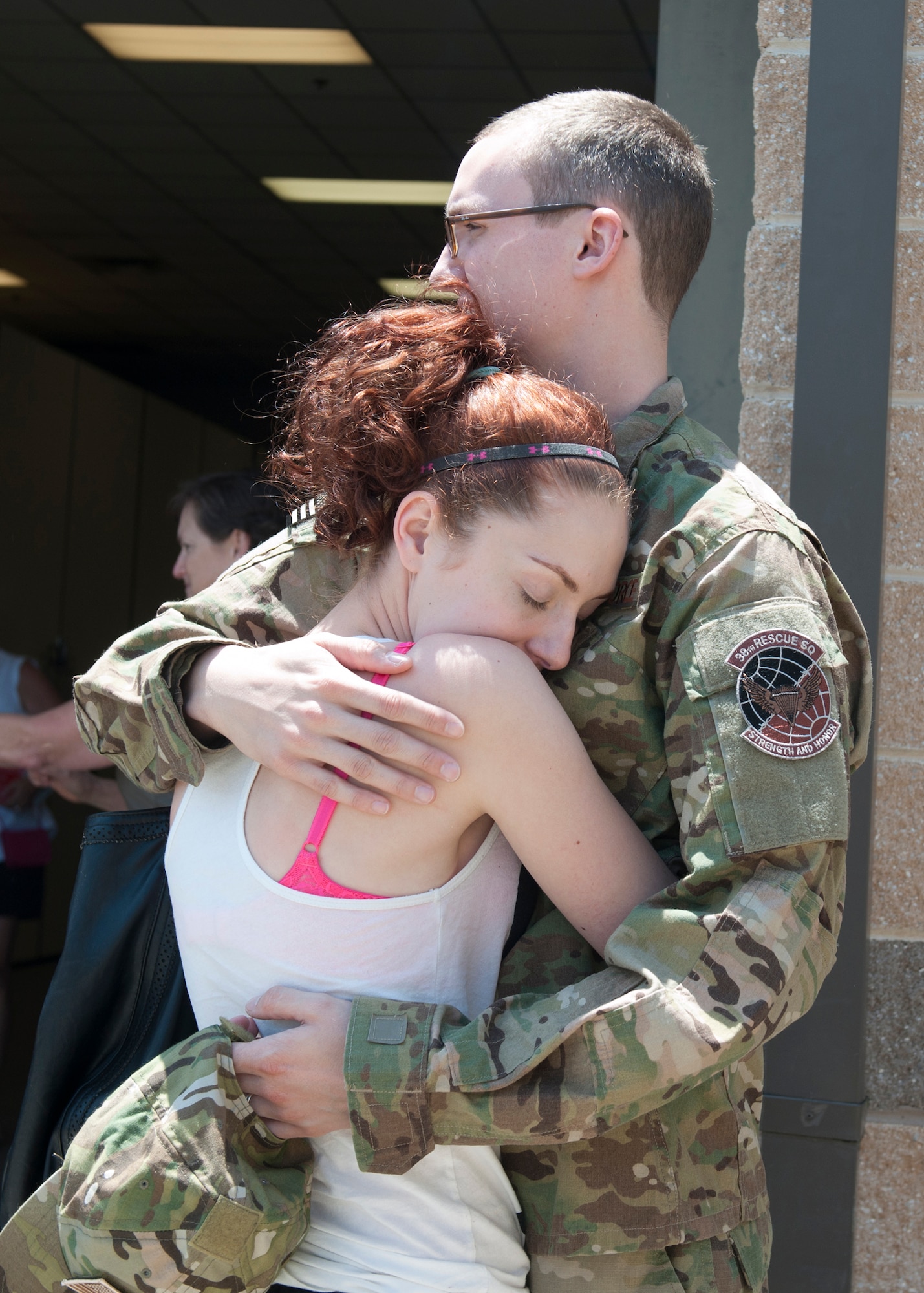 U.S. Air Force Airman 1st Class Matthew Purol, 38th Rescue Squadron, says his last goodbyes at Moody Air Force Base, Ga., May 24, 2012, before deploying to Afghanistan with a National Geographic video crew that will accompany the unit for the entire deployment. National Geographic arrived the night prior to departure and documented the 38th RQS Airmen’s last moments with their families before leaving. (U.S. Air Force photo by Senior Airman Eileen Meier/Released)