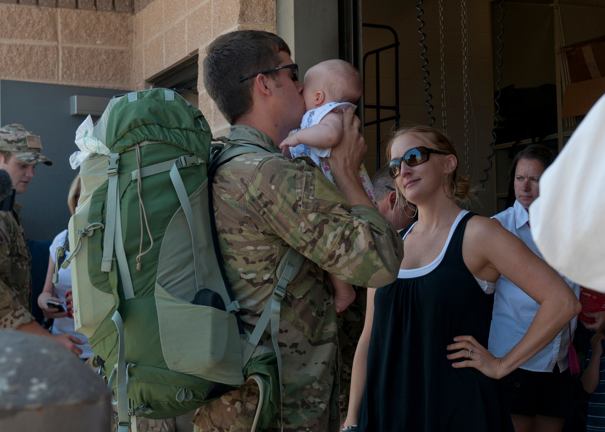 U.S. Air Force Capt. Eric Hansen, 38th Rescue Squadron, kisses his baby girl before leaving to Afghanistan with crew members from National Geographic at Moody Air Force Base, Ga., May 24, 2012. National Geographic is currently working on a six-episode series that will feature pararescuemen from various units, documenting rescue missions down range. (U.S. Air Force photo by Senior Airman Eileen Meier/Released)