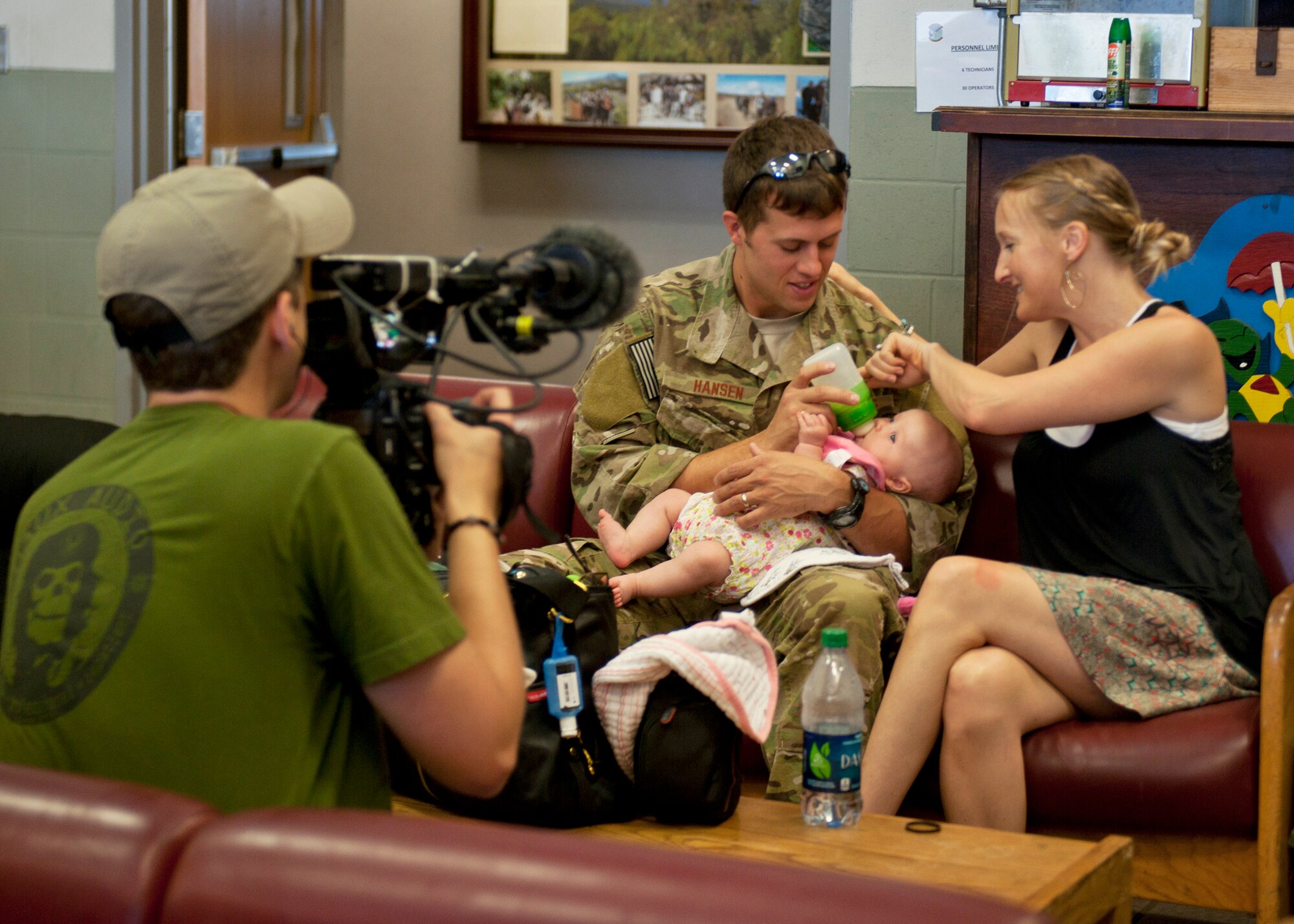 U.S. Air Force Capt. Eric Hansen, 38th Rescue Squadron, feeds his baby daughter before leaving for Afghanistan while a National Geographic crew member gets footage for a six-episode series on pararescuemen at Moody Air Force Base, Ga., May 24, 2012. The National Geographic team will embed with the PJs to document their missions down range saving the lives of others. (U.S. Air Force photo by Senior Airman Eileen Meier/Released)
