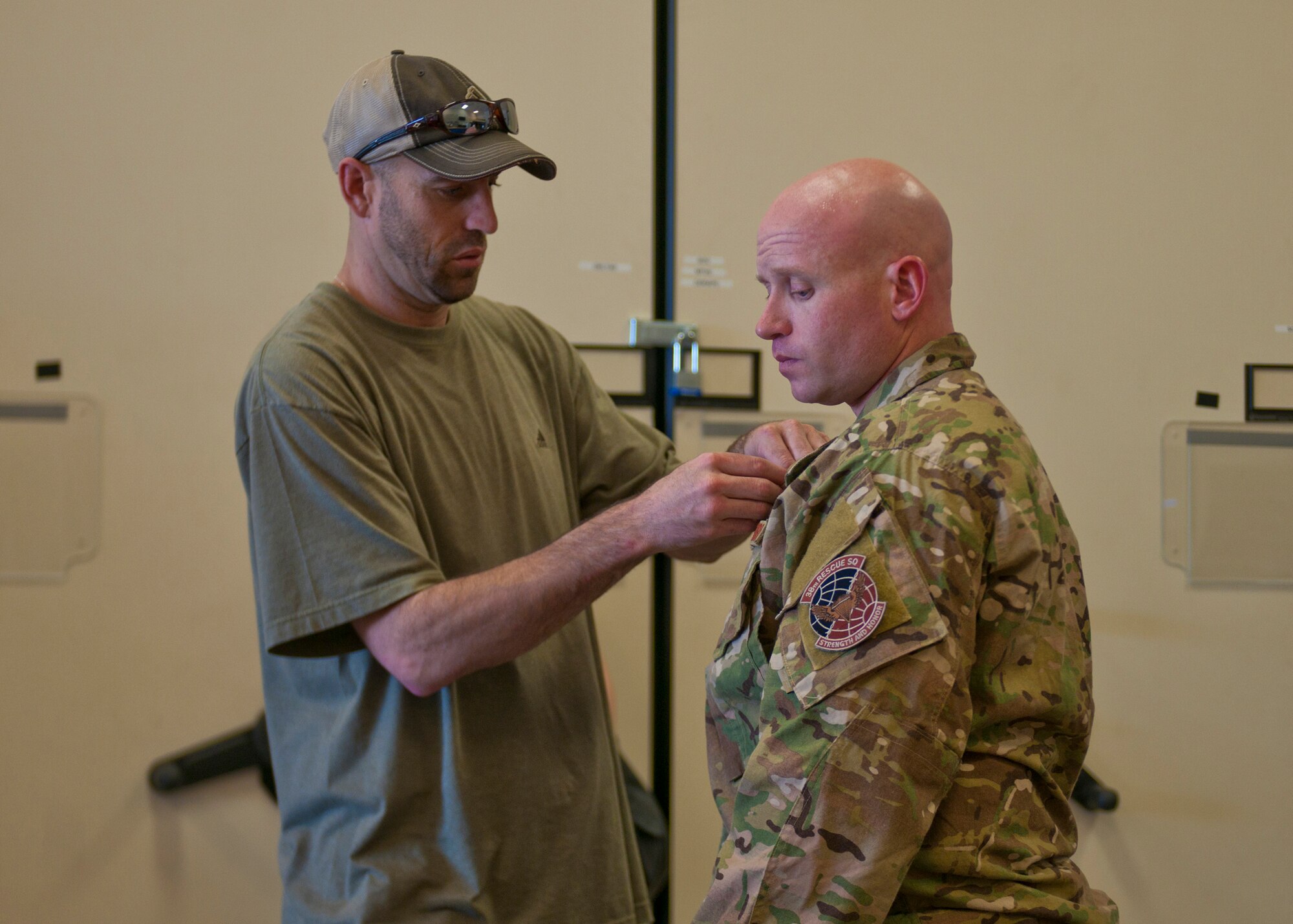A member of the National Geographic crew attaches a microphone to U.S. Air Force Capt. Seth Davis, 38th Rescue Squadron, for a six-episode series on pararescuemen from several different squadrons including Airmen from the 38th RQS at Moody Air Force Base, Ga., May 24, 2012. The National Geographic crew began documenting the PJs and their families the night prior to departing to Afghanistan. (U.S. Air Force photo by Senior Airman Eileen Meier/Released)