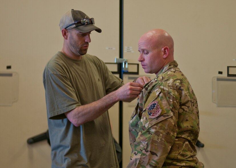 A member of the National Geographic crew attaches a microphone to U.S. Air Force Capt. Seth Davis, 38th Rescue Squadron, for a six-episode series on pararescuemen from several different squadrons including Airmen from the 38th RQS at Moody Air Force Base, Ga., May 24, 2012. The National Geographic crew began documenting the PJs and their families the night prior to departing to Afghanistan. (U.S. Air Force photo by Senior Airman Eileen Meier/Released)
