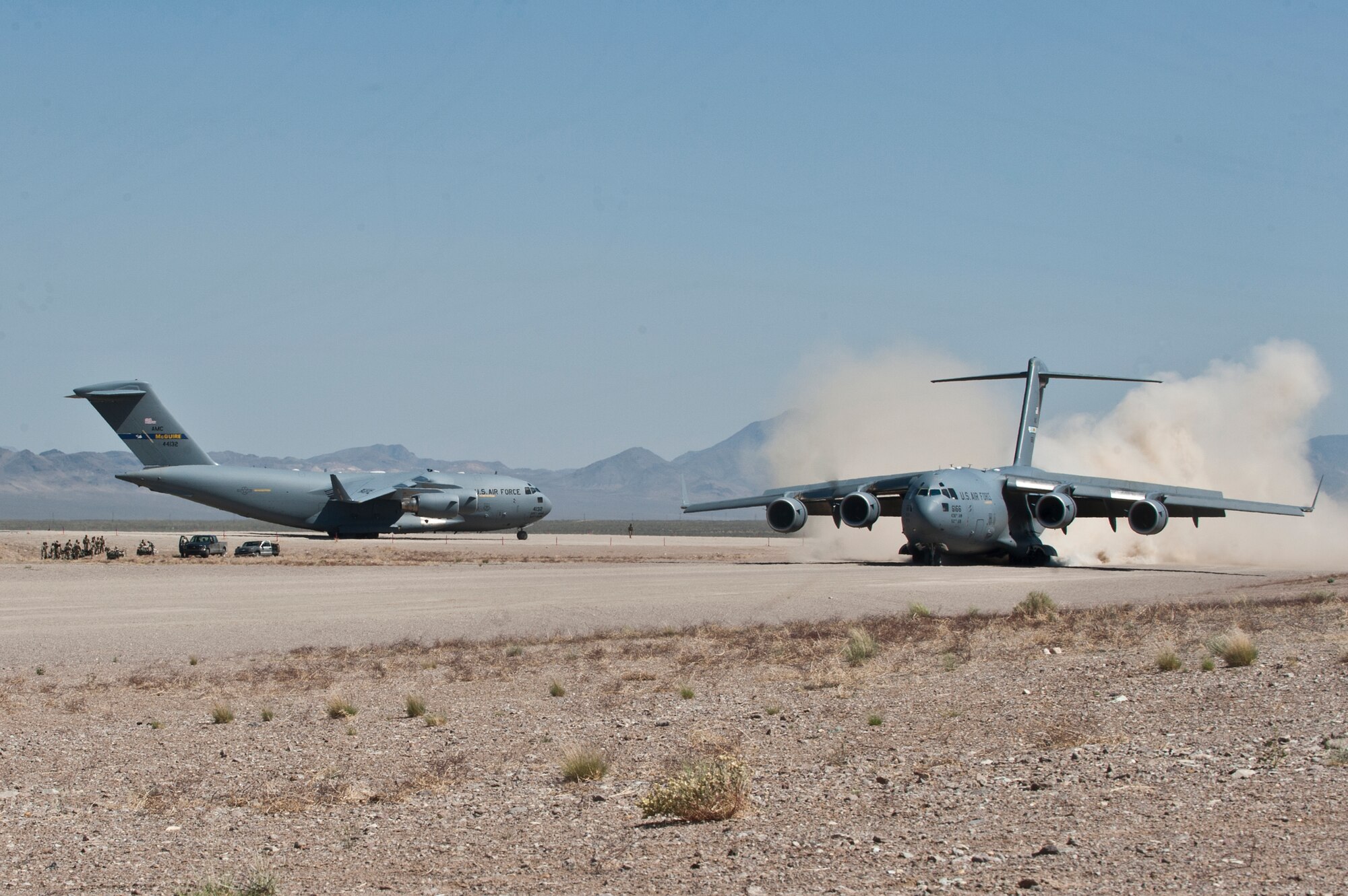 Two U.S. Air Force C-17 Globemaster IIIs prepare to take off from a dirt runway during a Mobility Air Forces Exercise May 23, 2012, at the Nevada Test and Training Range. The aircraft conducted simulated and actual low-altitude drops of airborne forces. (U.S. Air Force photo/Airman 1st Class Jason Couillard)

