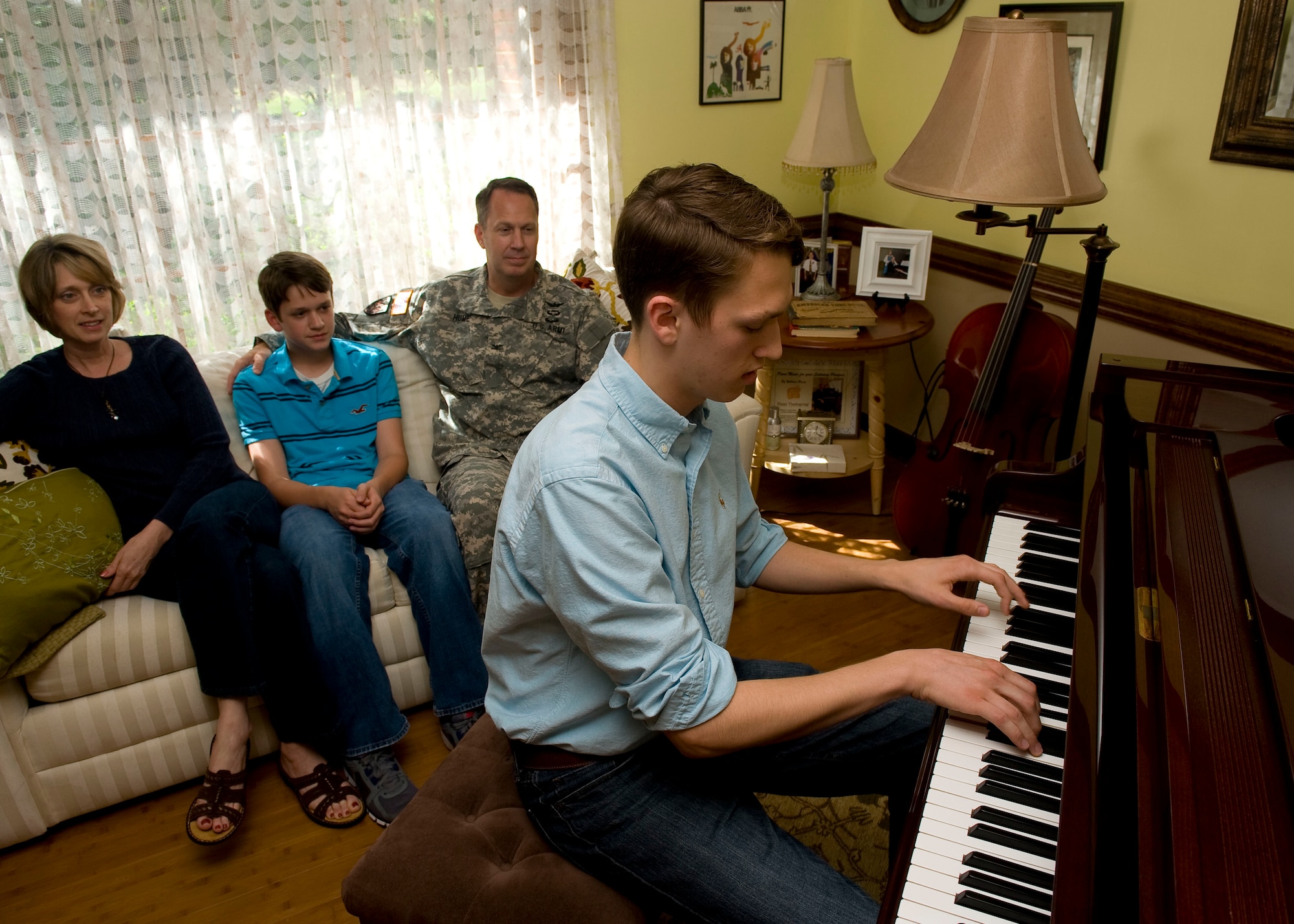William Hume plays his Schimmel piano for his father, U.S. Army Col. Robert Hume, the Army Capabilities Integration Center Studies and Analysis Division chief, and family at their home in Yorktown, Va., May 21, 2012.  William first experienced piano as a child, learning on an upright piano inherited from his great-grandmother. (U.S. Air Force photo by Senior Airman John D. Strong II/Released)