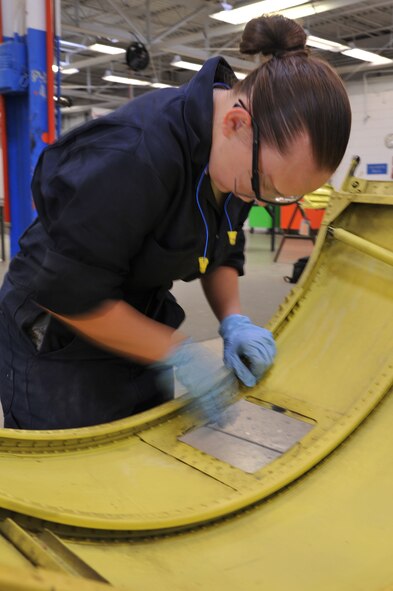 MINOT AIR FORCE BASE, N.D. -- Airman 1st Class Cynthia Adams, 5th Maintenance Squadron aircraft structural maintenance journeyman, sands a piece of equipment here May 22. The 5th MXS supports the 5th Bomb Wing by providing equipment maintenance on its B-52H Stratofortresses. (U.S. Air Force photo/Senior Airman Brittany Y. Auld)