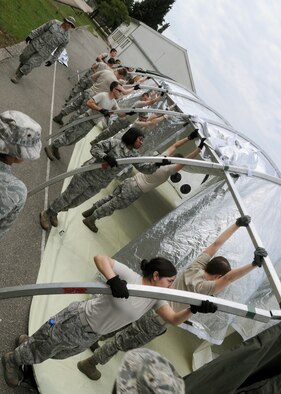 Participants of Shared Resilience 2012 attach side arches of an Alaskan tent during the Expeditionary Medical Support course here, May 30, 2012. During the course, instructors from Joint Base San Antonio, Texas, taught more than 50 U.S. military members how to set up and operate a medical facility in a deployed environment. More than 500 military members from nine nations are participating in SR12, an annual U.S. Joint Chiefs of Staff sponsored exercise, May 28 - June 8. The goals of the exercise are to strengthen interoperability, facilitate training in crisis response and disaster management, and validate the readiness of deployable military medical and humanitarian assistance teams. The exercise, in the spirit of partnership for peace, directly supports U.S. European Command's theater cooperation efforts and strategy for active security with European countries.