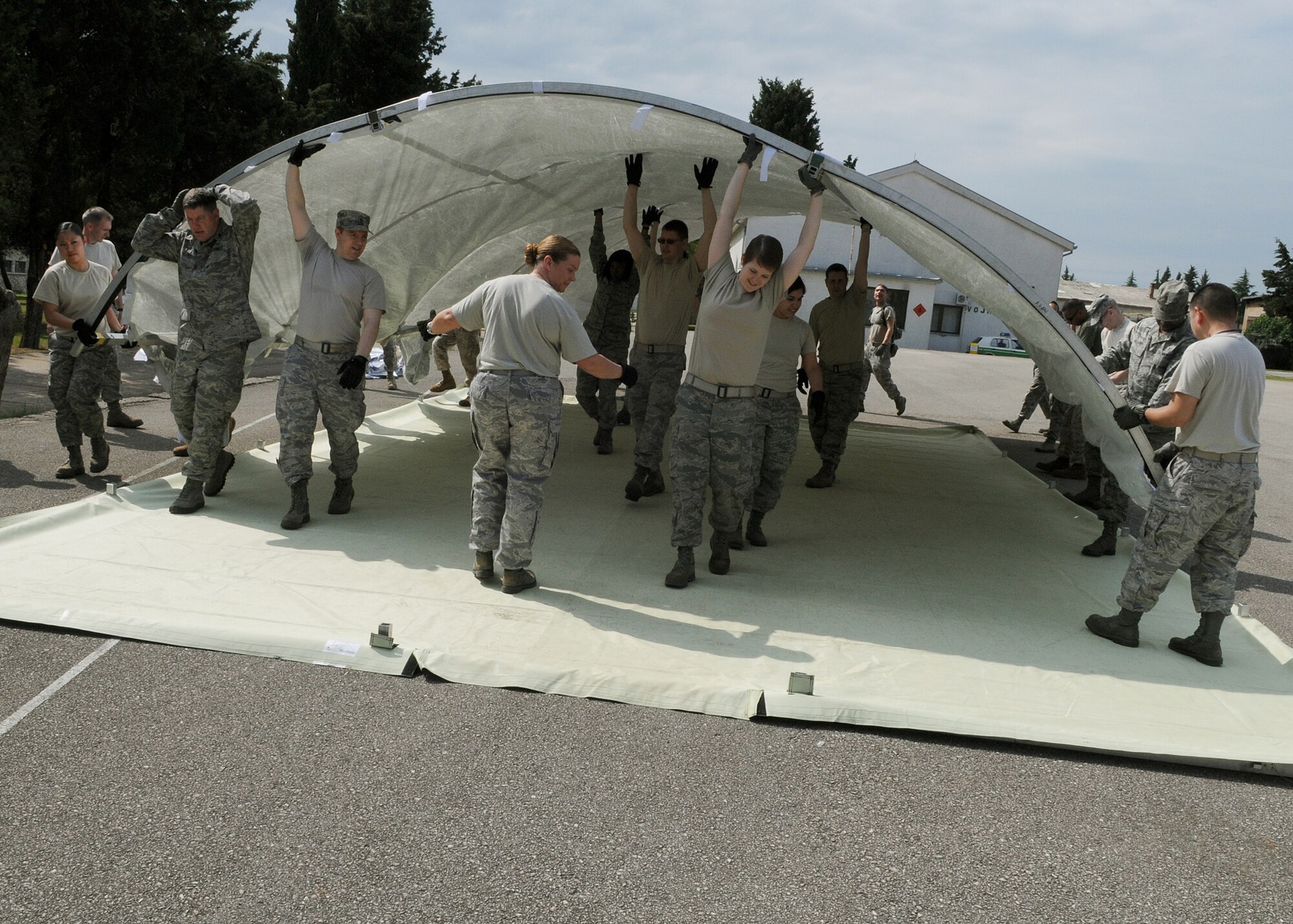Participants of Shared Resilience 2012 move the top of an Alaskan tent during the Expeditionary Medical Support course here, May 30, 2012. During the course, instructors from Joint Base San Antonio, Texas, taught more than 50 U.S. military members how to set up and operate a medical facility in a deployed environment. More than 500 military members from nine nations are participating in SR12, an annual U.S. Joint Chiefs of Staff sponsored exercise, May 28 - June 8. The goals of the exercise are to strengthen interoperability, facilitate training in crisis response and disaster management, and validate the readiness of deployable military medical and humanitarian assistance teams. The exercise, in the spirit of partnership for peace, directly supports U.S. European Command's theater cooperation efforts and strategy for active security with European countries.