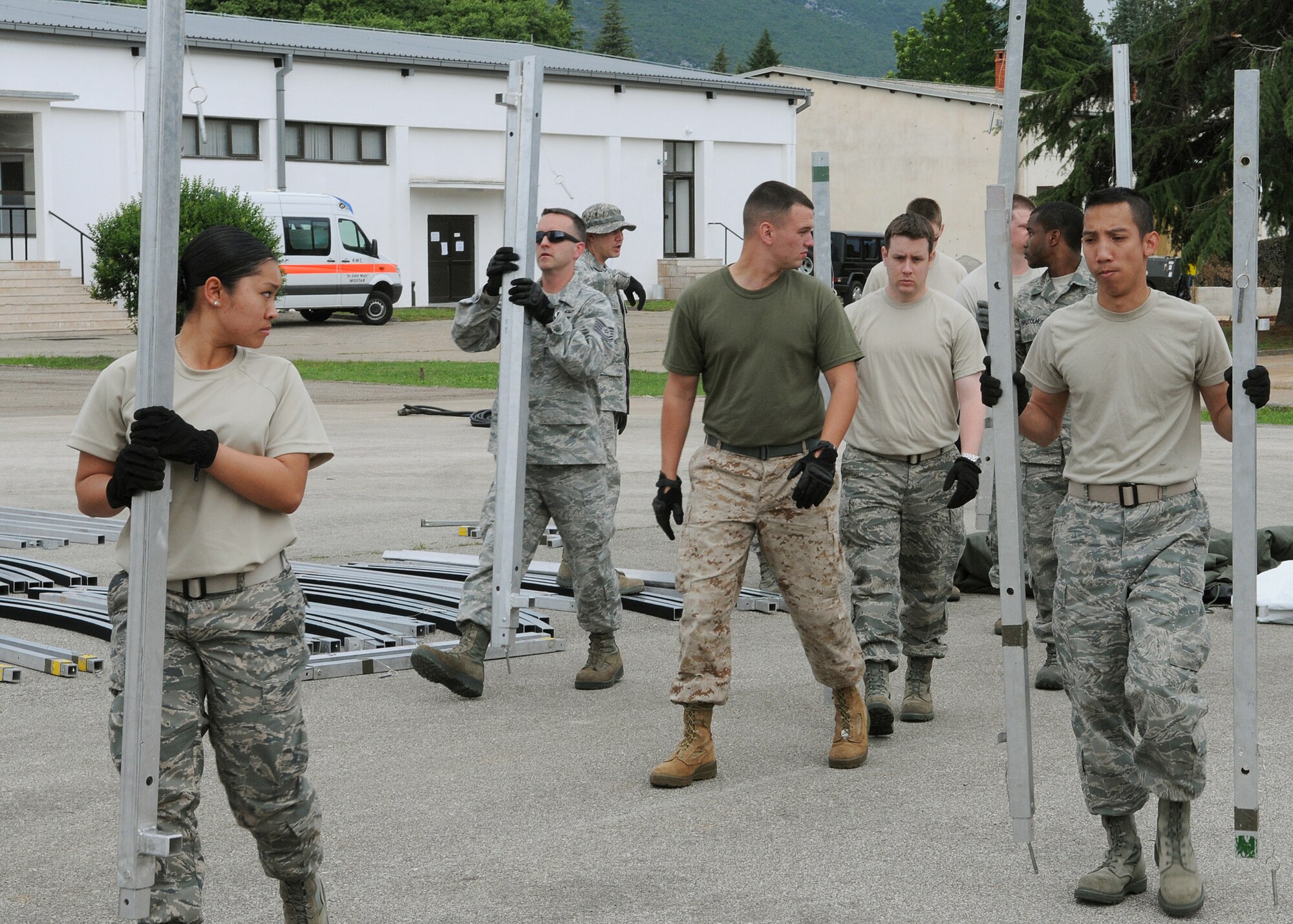 Participants of Shared Resilience 2012 move Alaskan tent arch poles during the Expeditionary Medical Support course here, May 30, 2012. During the course, instructors from Joint Base San Antonio, Texas, taught more than 50 U.S. military members how to set up and operate a medical facility in a deployed environment. More than 500 military members from nine nations are participating in SR12, an annual U.S. Joint Chiefs of Staff sponsored exercise, May 28 - June 8. The goals of the exercise are to strengthen interoperability, facilitate training in crisis response and disaster management, and validate the readiness of deployable military medical and humanitarian assistance teams. The exercise, in the spirit of partnership for peace, directly supports U.S. European Command's theater cooperation efforts and strategy for active security with European countries.