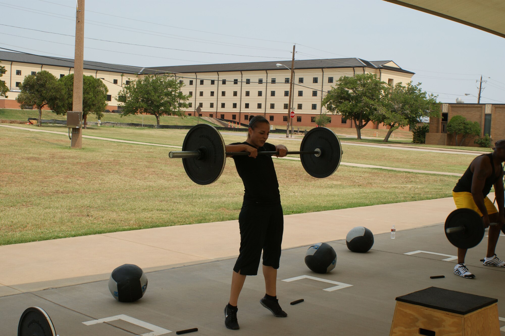 Carly Martinez, spouse of Tech. Sgt. Jaime Martinez of the 361st Training Squadron, pumps iron during the "Combat Fit" workout outside the Pitsenbarger Fitness Center May 24, 2012.  Martinez has seen dramatic improvement in her overall fitness levels since committing to the "Combat Fit" program five months ago. (U.S. Air Force photo/2Lt Jerred Moon)
