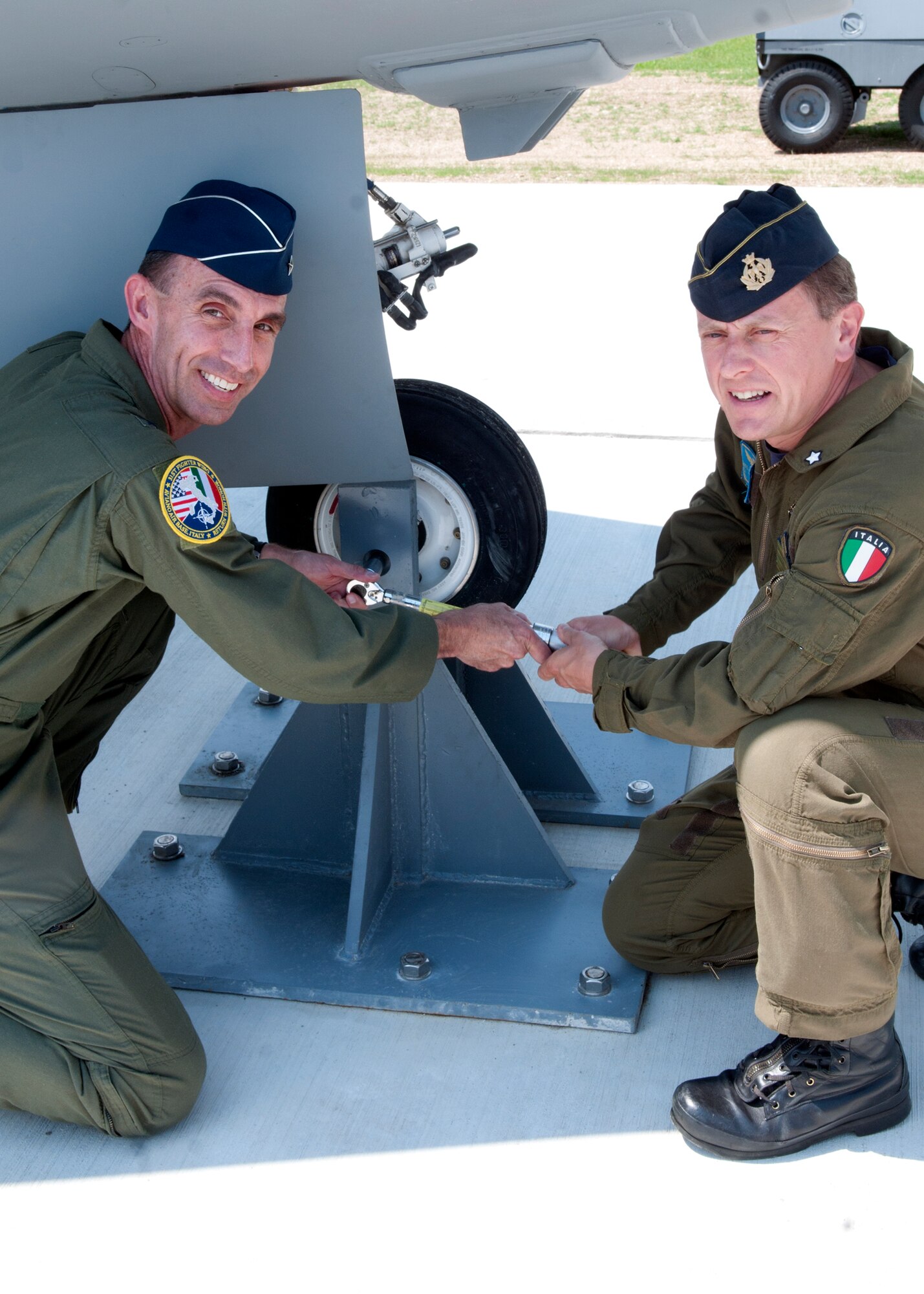 (From left) Brig. Gen. Scott Zobrist, 31st Fighter Wing commander and Col. Luca Capelli, Pagliano e Gori Airport commander, secure the new static display May 29 at Aviano Air Base, Italy.  The aircraft was one of 34 F-16s supplied to the Italian air force as part of the Peace Caesar Program in 2003. (U.S. Air Force photo/Airman 1st Class Briana Jones) 