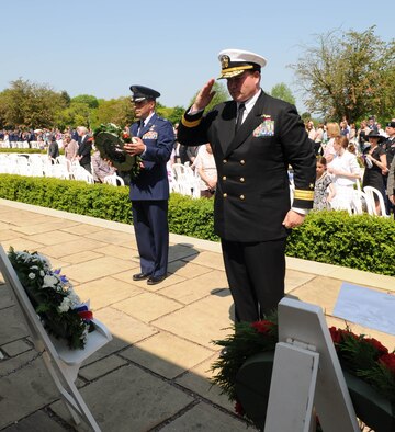 MADINGLEY, England – Navy Rear Adm. Mark Montgomery, representing U.S. European Command, salutes a wreath that he laid at the Wall of the Missing on behalf of the United States and U.S. European Command, during the 68th Annual Memorial Day Observance May 28, 2012 at the Cambridge American Cemetery. The ceremony honors Service members who are buried in the cemetery. (U.S. Air Force photo/Senior Airman Rachel Waller)  