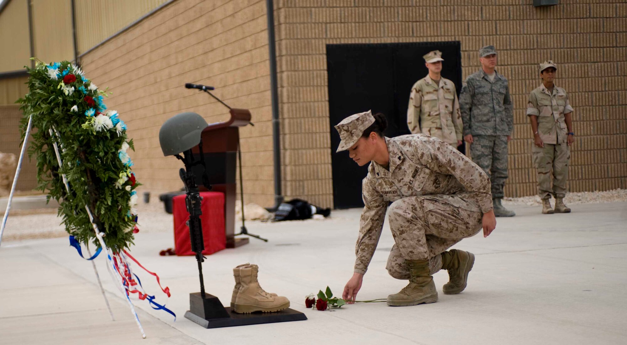 U.S. Marine Crops Cpl. Jenequa Benavente, Marine Detachment, places a rose at the base of a Fallen Warrior Battle Cross during the Memorial Day remembrance ceremony in Southwest Asia, May 28, 2012. The Fallen Warrior Battle Cross honors those who have lost their lives in the line of duty while serving in and armed conflict. More than 150 people attended the ceremony honoring their fallen Service members. (U.S. Air Force photo/Staff Sgt. Sheila deVera)